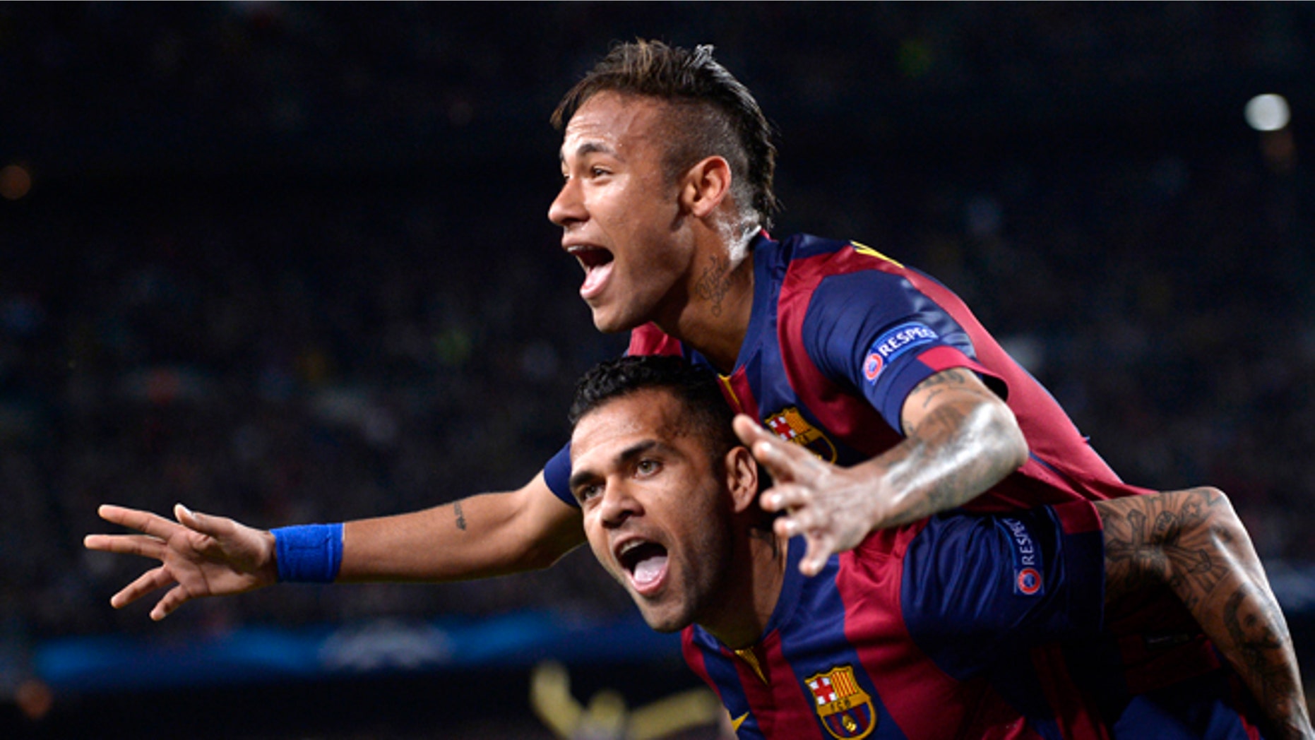 Barcelona's Neymar celebrates on the shoulders of teammate Dani Alves, after scoring his second goal during the Champions League quarterfinal second leg soccer match between FC Barcelona and Paris Saint Germain at the Camp Nou Stadium in Barcelona, Spain, Tuesday, April 21, 2015. (AP Photo/Manu Fernandez)