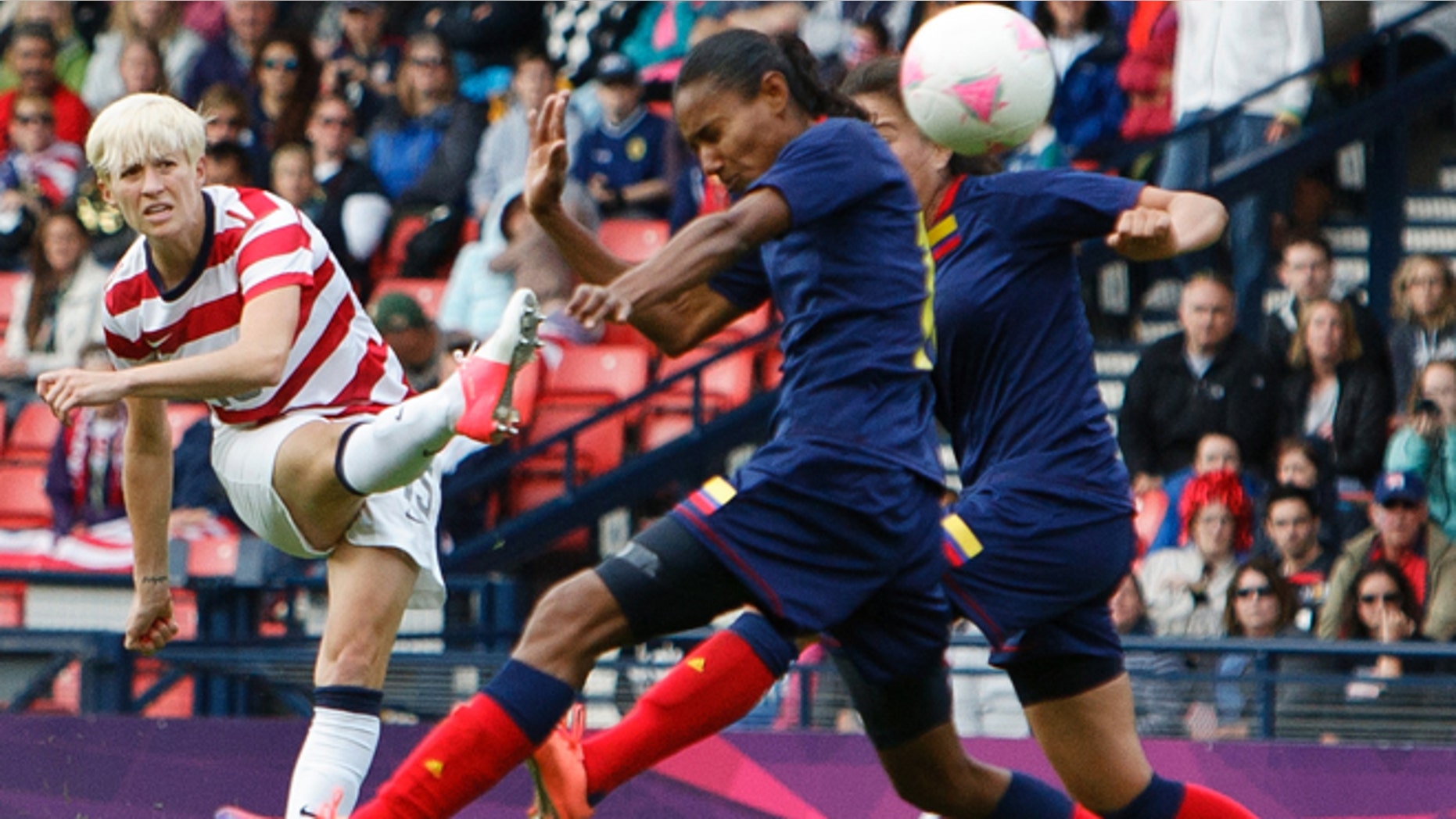 July 28, 2012: United States' Megan Rapinoe, left, shoots and scores the opening goal during the group G women's soccer match between the United States and Colombia at the London 2012 Summer Olympics in Glasgow, Scotland.
