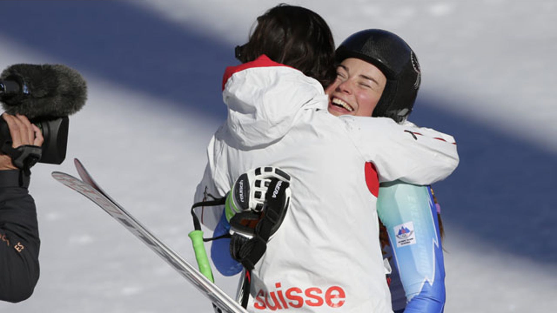 February 12, 2014: Slovenia's Tina Maze, right, and Switzerland's Dominique Gisin embrace after finishing the women's downhill at the Winter Olympics. (AP Photo/Gero Breloer)