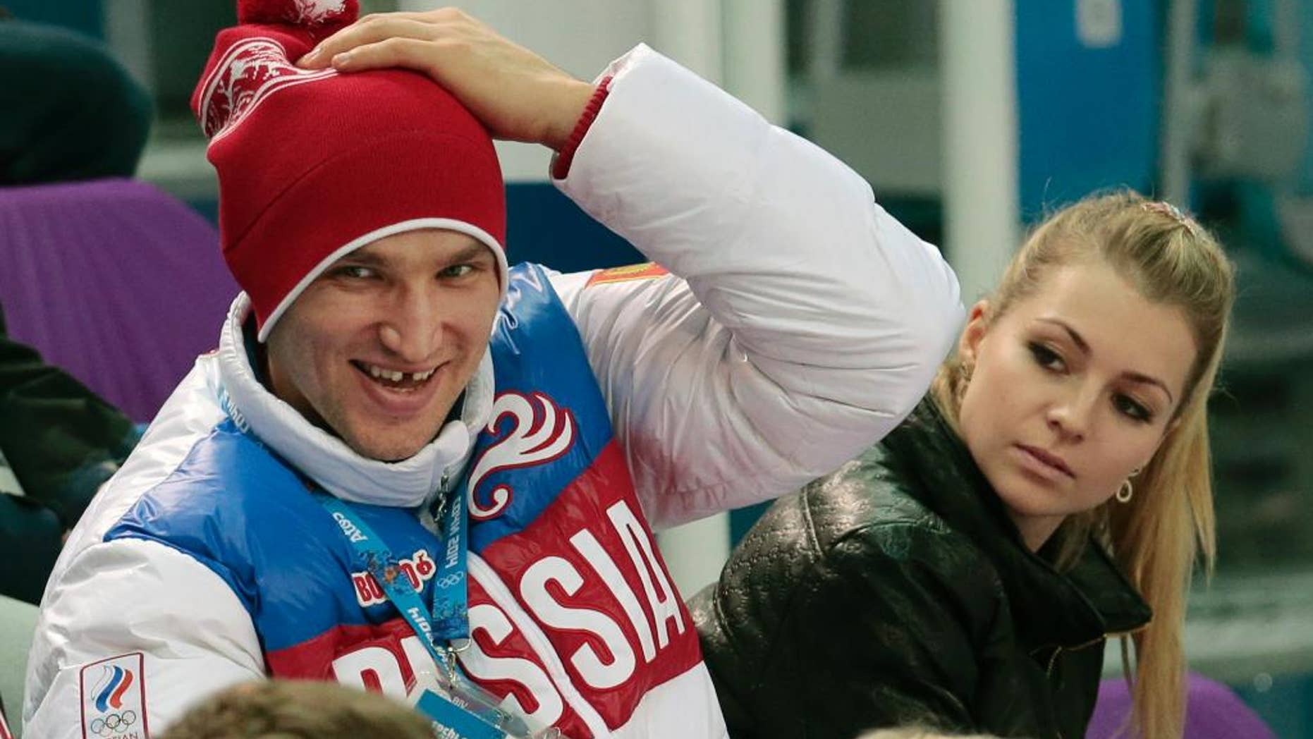 FILE - In this Tuesday, Feb. 11, 2014 file photo, Russian ice hockey player Alexander Ovechkin, left, and retired Russian tennis player Maria Kirilenko attend the pairs short program figure skating competition at the Iceberg Skating Palace during the 2014 Winter Olympics in Sochi, Russia. Russian tennis player Maria Kirilenko says she has broken off her planned wedding to Ovechkin of the Washington Capitals. The two had been together since 2011 and became engaged in December 2012. (AP Photo/Ivan Sekretarev, File)