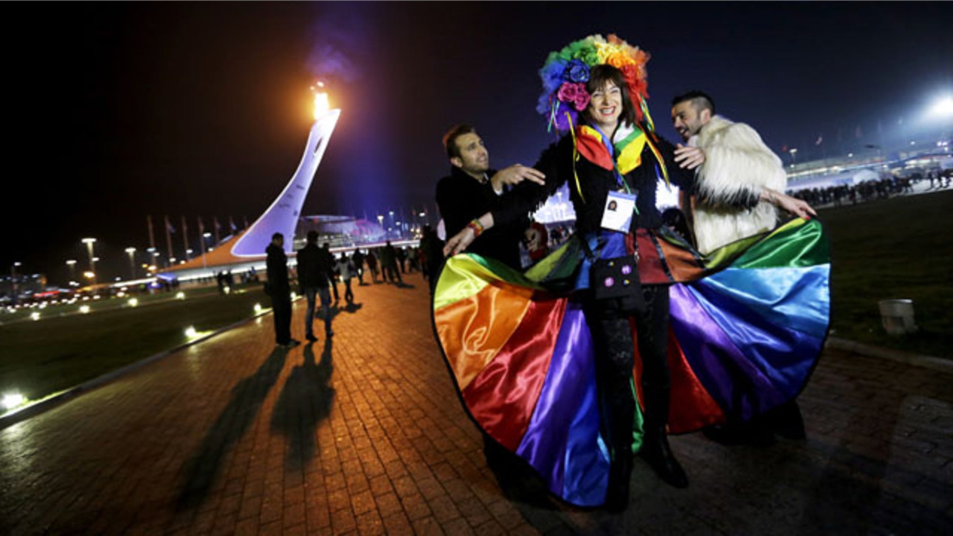 February 17, 2014: Vladimir Luxuria, center, a former Communist lawmaker in the Italian parliament and prominent crusader for transgender rights, is led away by friends to attend a women's ice hockey match after posing for photos on the Olympic Plaza at the 2014 Winter Olympics in Sochi, Russia. Luxuria was soon after detained by police upon entering the Shayba Arena. (AP Photo/David Goldman)