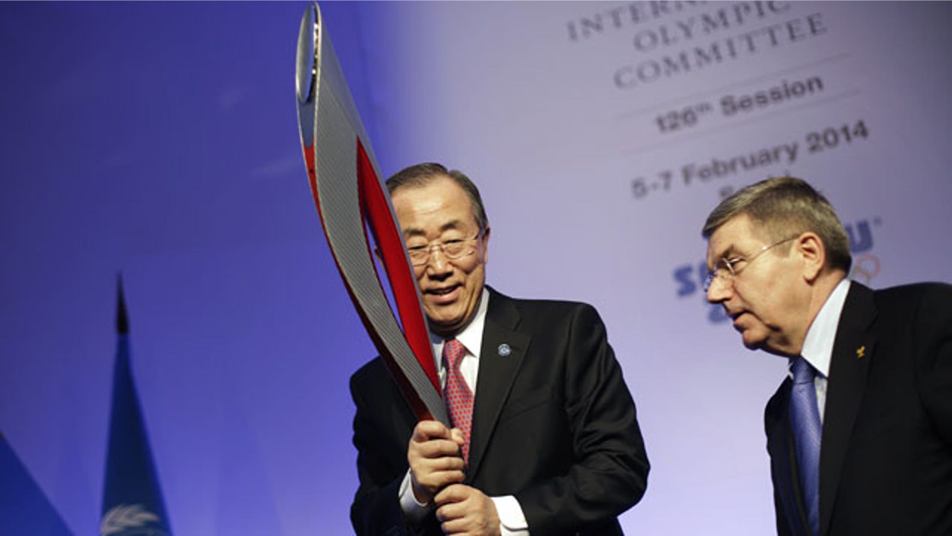 February 6, 2014: United Nations Secretary-General Ban Ki-moon, left, is handed an Olympic torch by International Olympic Committee President Thomas Bach after Ban addressed the IOC general assembly ahead of the upcoming Winter Olympics. (AP Photo/David Goldman)