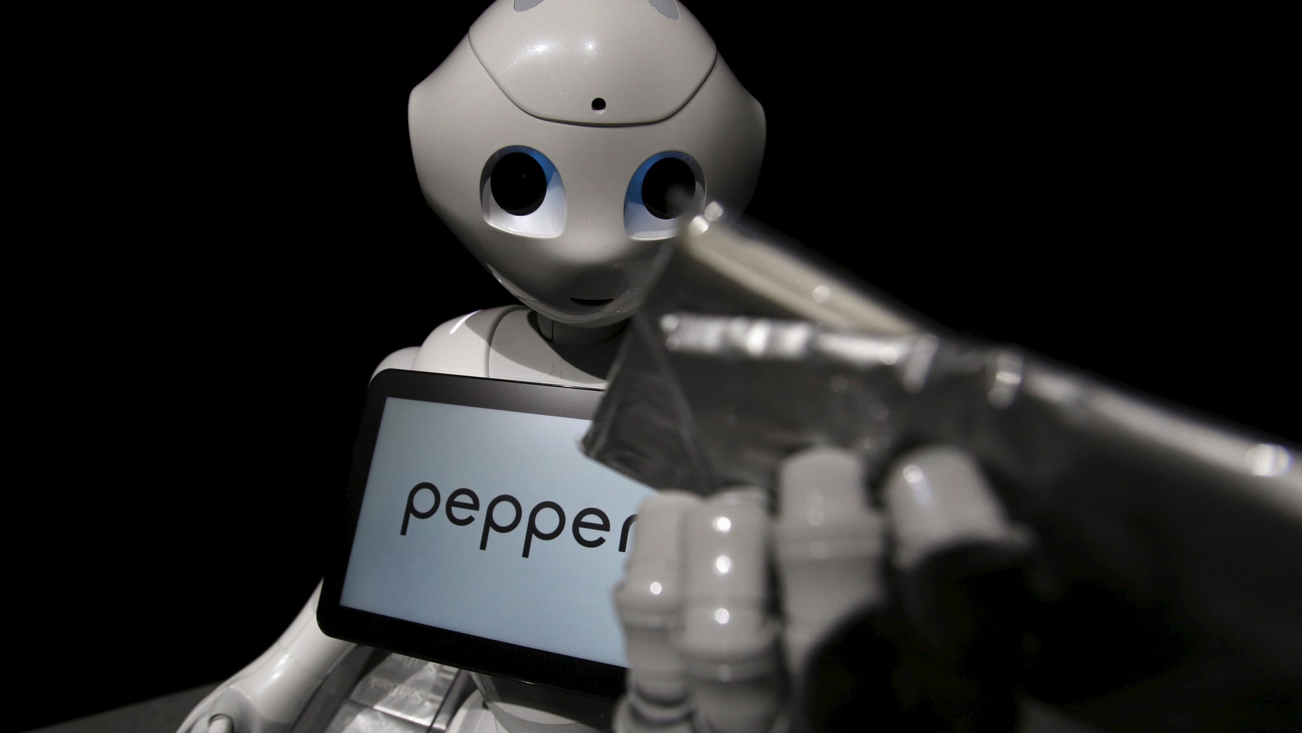 SoftBank's human-like robot named "pepper" performs distributing a pack of tissue paper as a part-time worker during a news conference in Chiba, Japan, June 18, 2015.