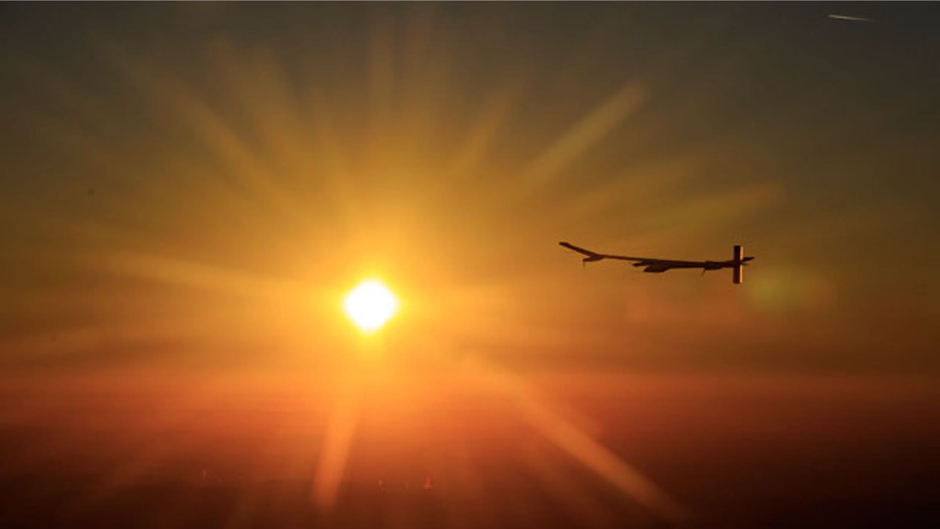 July 8: Solar Impulse's Chief Executive Officer and pilot Andre Borschberg fly in the solar-powered HB-SIA prototype airplane after its first night flight attempt near Payerne airport, Switzerland, as the sun rises. (AP)