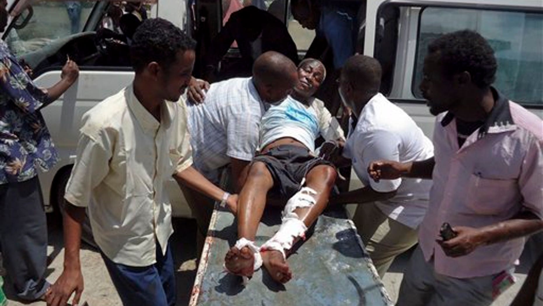 April 4, 2012: Medical personnel help a man wounded in a blast at the Somali National Theater in Mogadishu, Somalia.