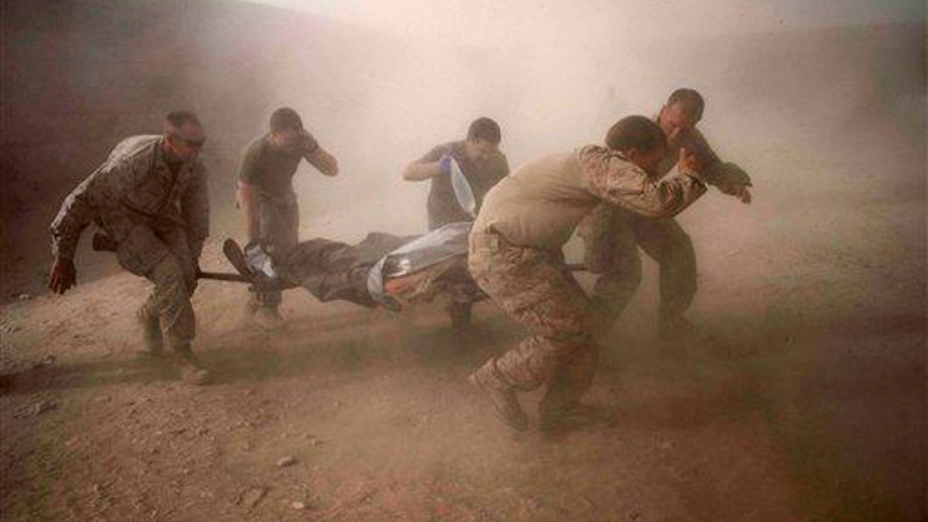 US Marines rush a colleague wounded in an IED strike in the volatile Helmand Province of southern Afghanistan on Tuesday, May 10, 2011.