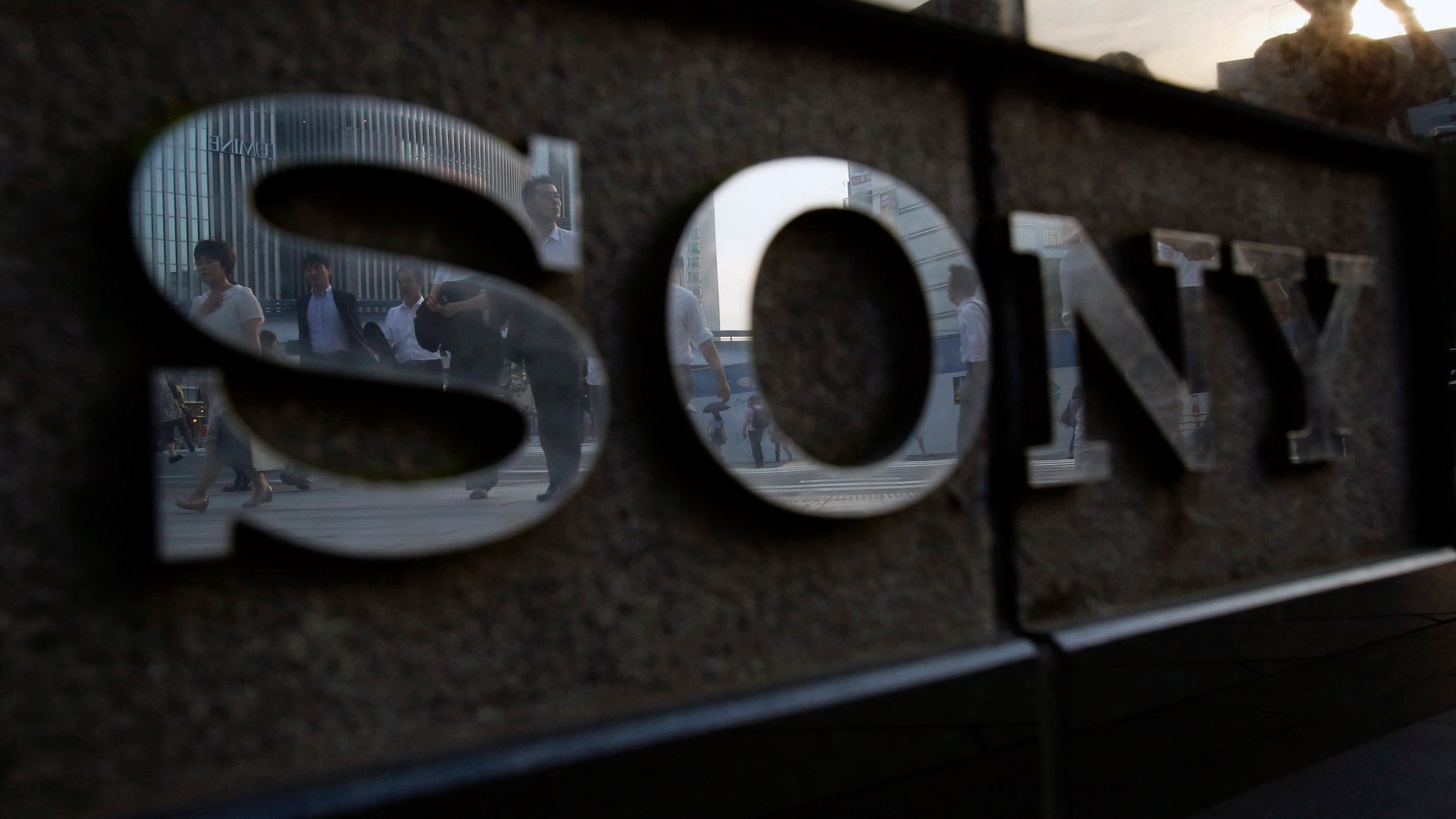 File photo - Pedestrians are reflected in a logo of Sony Corp outside its showroom in Tokyo July 16, 2014.