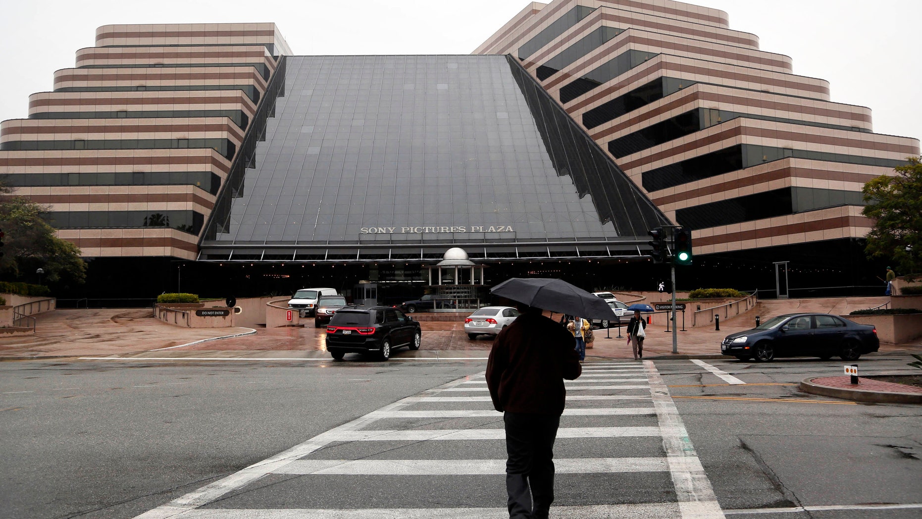 Pedestrians cross a street in front of the Sony Pictures Entertainment headquarters in Culver City, Calif. on Dec. 2, 2014.