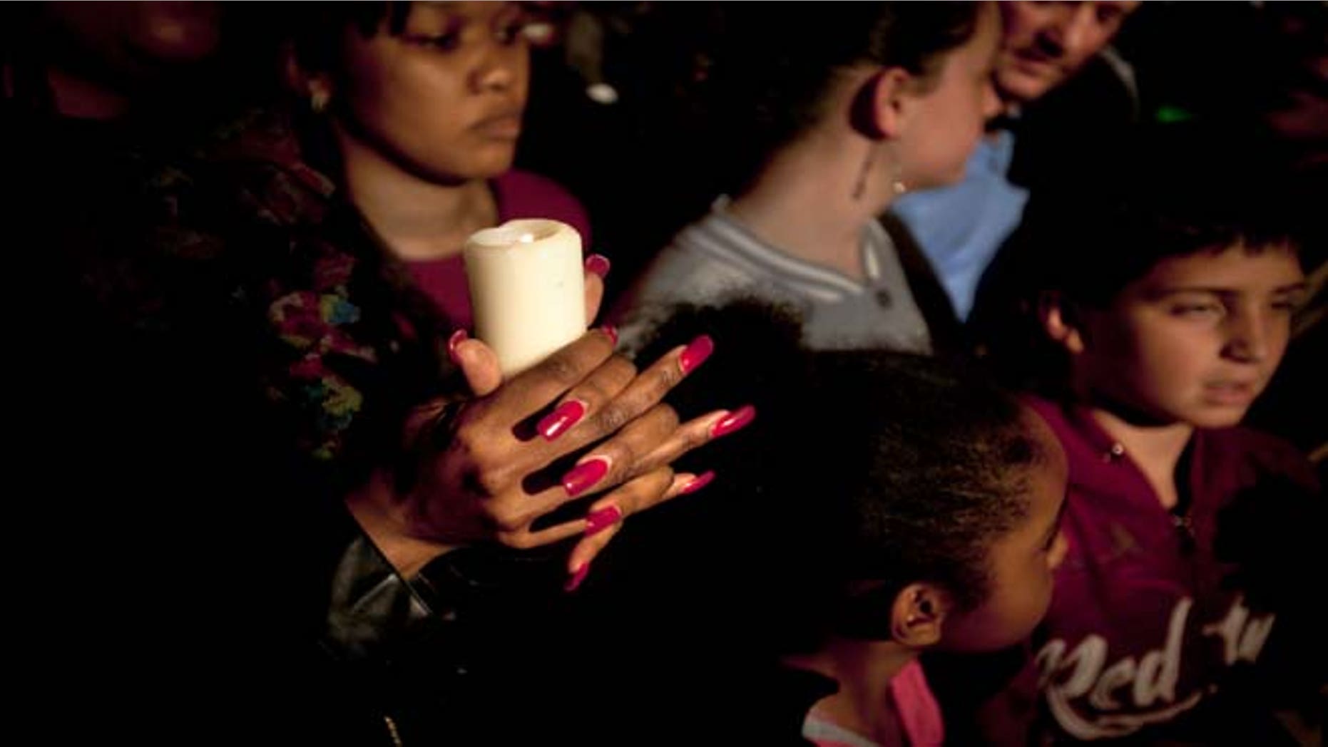 A woman from a community group based in Pretoria holds a candle and sings religious songs to show appreciation and support for former South African President, Nelson Mandela, on the street outside the Mediclinic Heart Hospital where he is being treated in Pretoria, South Africa Tuesday, June 25, 2013. South Africa's president Jacob Zuma on Tuesday urged his compatriots to show their appreciation for Nelson Mandela, who is in critical condition in a hospital, by marking his 95th birthday next month with acts of goodness that honor the legacy of the anti-apartheid leader.