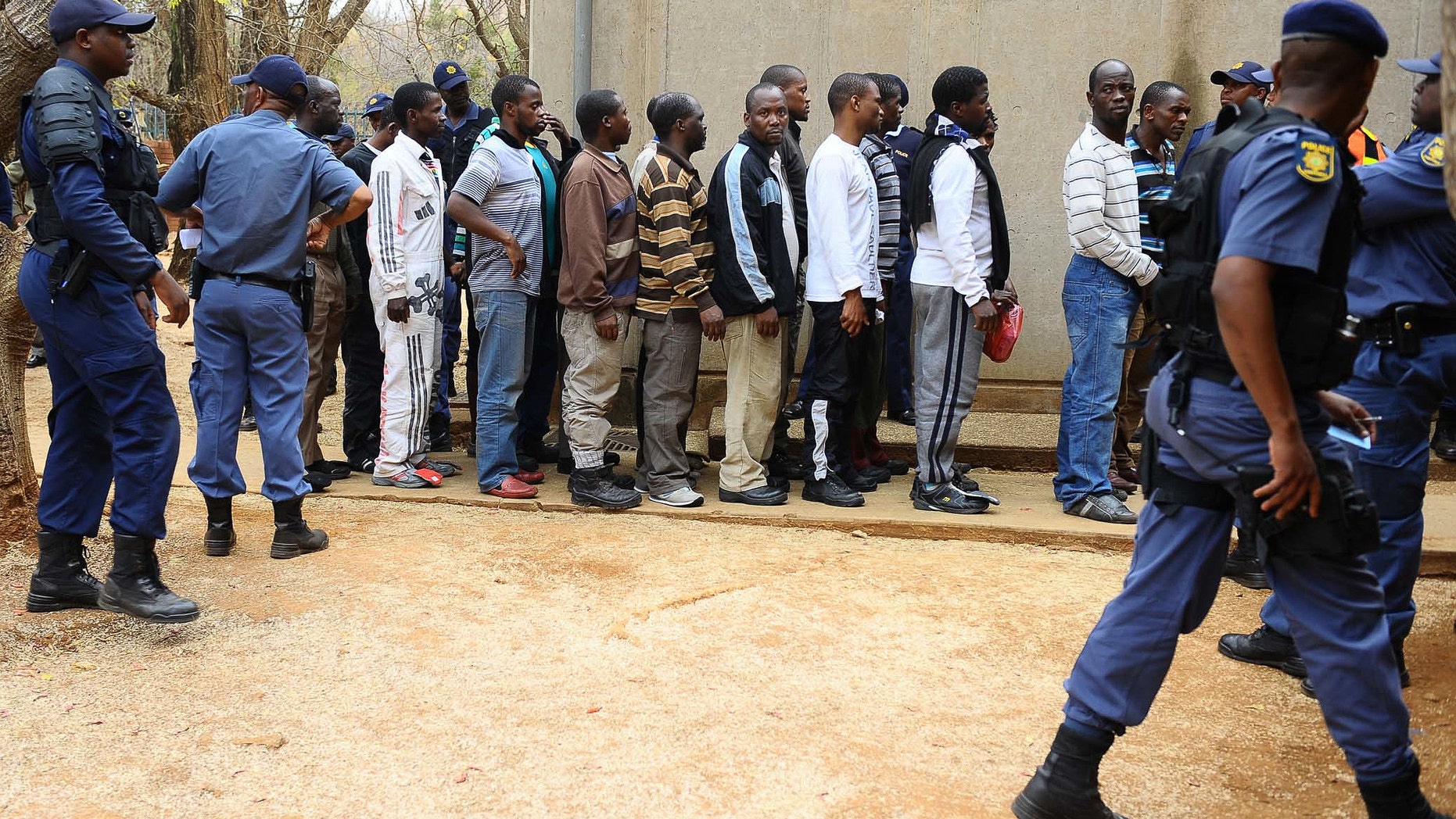 Aug. 27, 2012: Unidentified arrested mine workers await to be escorted into the court by police offers at the Ga-Rankuwa Magistrate Court in Pretoria, South Africa.