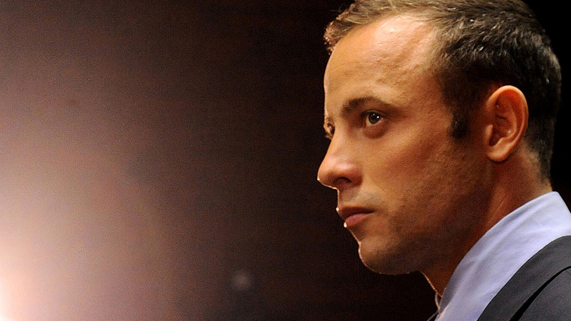 FILE - In this Friday, Feb. 22, 2013 file photo Olympic athlete Oscar Pistorius stands in the dock during his bail hearing at the magistrates court in Pretoria, South Africa. Pistorius is scheduled to re-appear in a South African court on Monday Aug.19, 2013. The the 26-year-old double-amputee Olympian will be indicted on a main charge of premeditated murder of his his girlfriend, Reeva Steenkamp. According to reports Sunday Aug.18, prosecutors have confirmed they will maintain the charge they initially laid against Pistorius (AP Photo/Themba Hadebe, File)