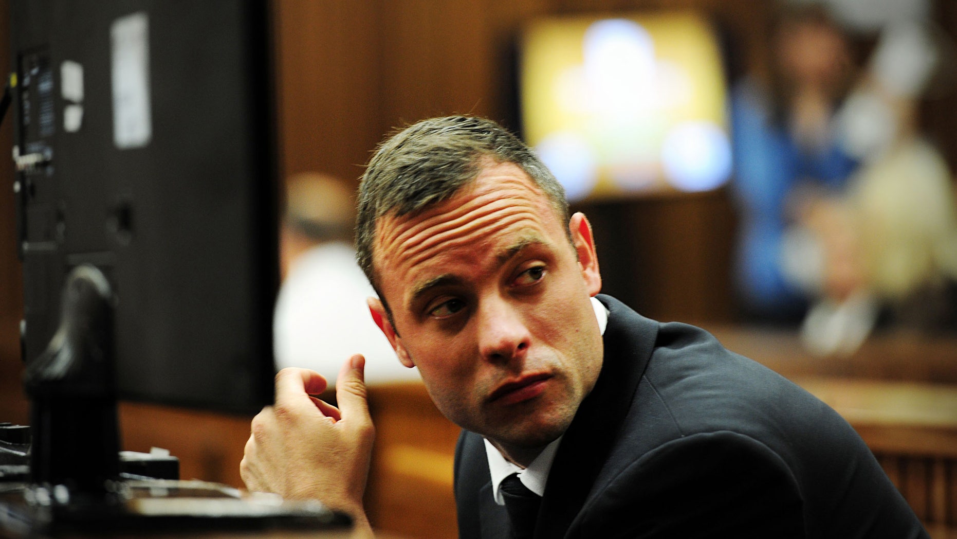 Oscar Pistorius glances sideways as he listens to ballistic evidence being given in court in Pretoria, South Africa, Wednesday, March 19, 2014. Pistorius is on trial for the murder of his girlfriend Reeva Steenkamp on Valentine's Day in 2013. (AP Photo/Leon Sadiki, Pool)