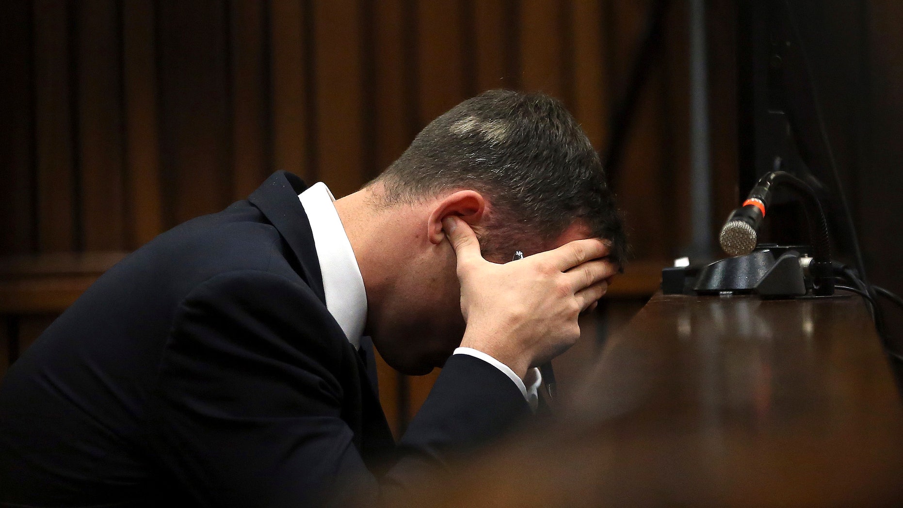 March 19, 2014: Oscar Pistorius, cradles his head in his hands as he listens to ballistic evidence being given in the court during his murder trial in Pretoria, South Africa.