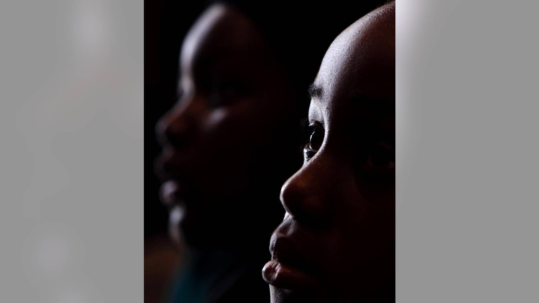 FILE - In this Thursday, July 18, 2013, file photo, students from the Melpark Primary School in Johannesburg listen to the history of former president Nelson Mandela as they celebrate the 95th birthday of Mandela during their school assembly. South Africa spent R238 billion, about $20 billion, on education in 2014, according to the treasury department. Yet, increased spending and experimental policies have not been able to overcome the obstacles left by a historically segregated schooling system. Basic Education Minister Angie Motshekga acknowledged during her televised announcement on Monday evening that preparation had to begin in kindergarten already. The government has introduced national exams to test basic math and language skills in lower grades, but South African scores are among the lowest in the world. (AP Photo/Denis Farrell, File)