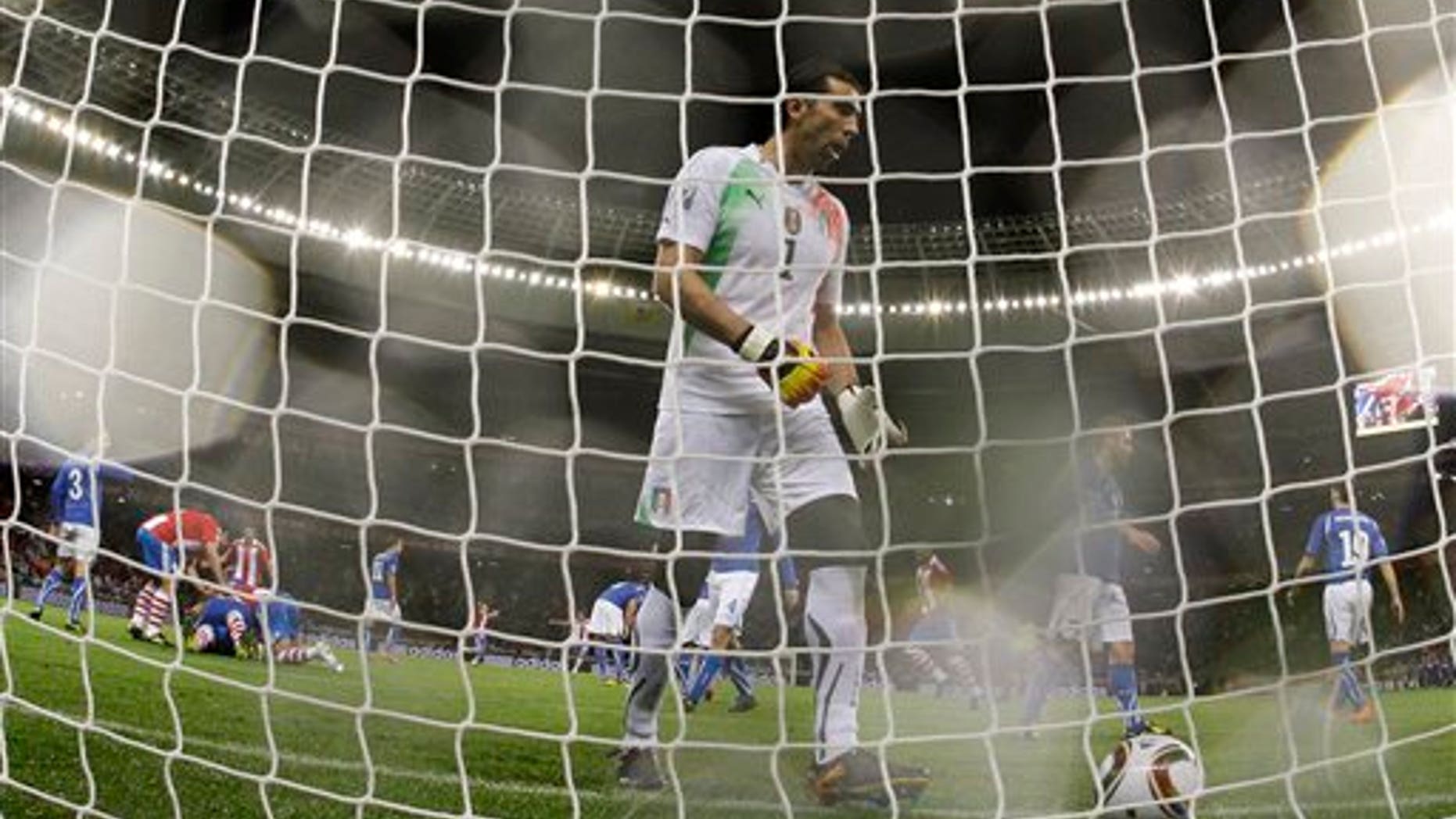 Italy goalkeeper Gianluigi Buffon, center, goes to pick up the ball after a penalty goal by Paraguay's Antolin Alcaraz, as fellow team members pile on top of him to celebrate, at left, during the World Cup group F soccer match between Italy and Paraguay in Cape Town, South Africa, Monday, June 14, 2010. (AP Photo/Roberto Candia)
