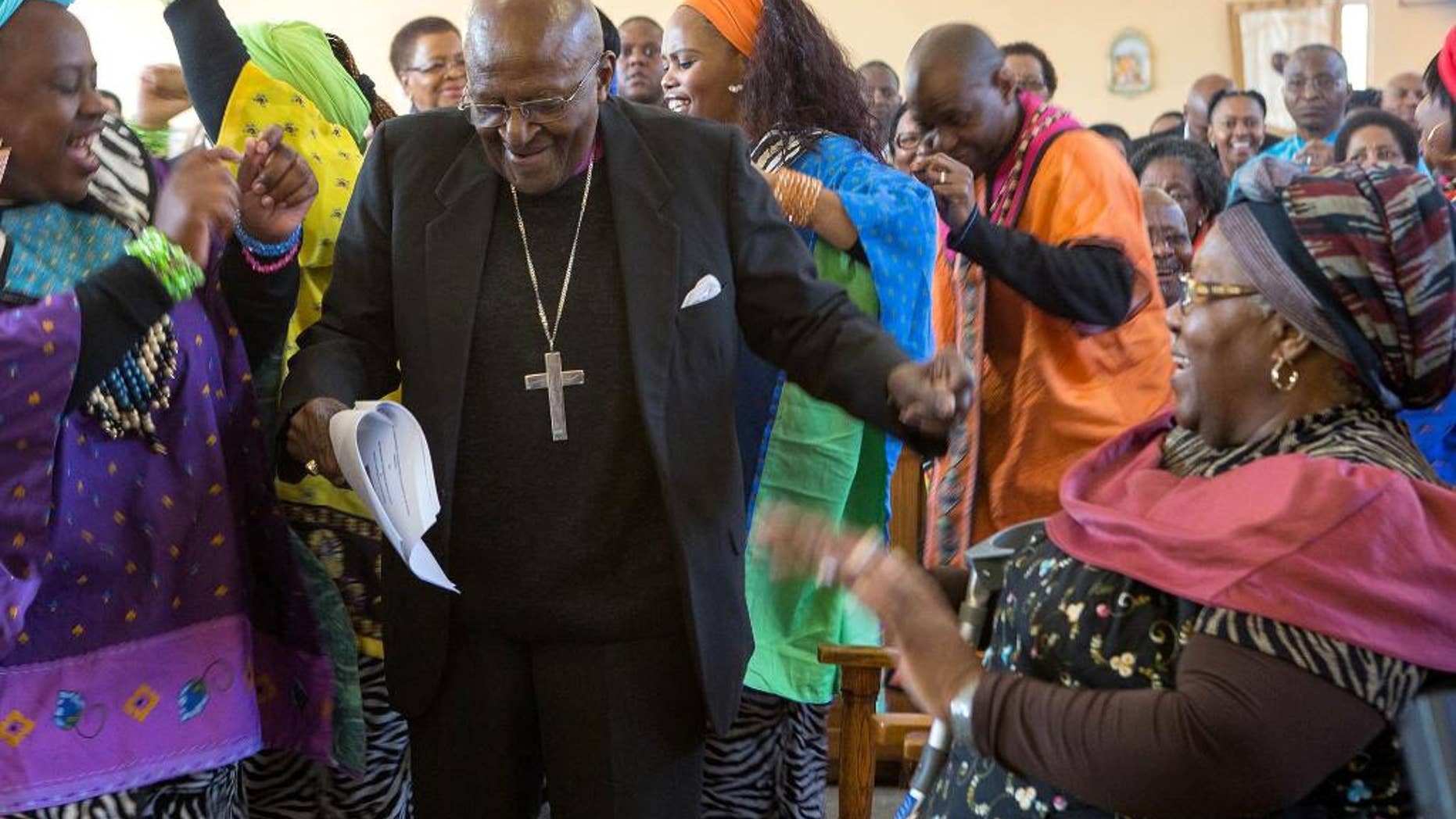 In this photo taken Saturday, July 4, 2015, retired Anglican Archbishop Desmond Tutu, centre, breaks into dance after renewing his wedding vows to his wife of 60 years, Leah, right, during a service in the Holy Cross Anglican Church in Soweto, Johannesburg. (AP Photo)