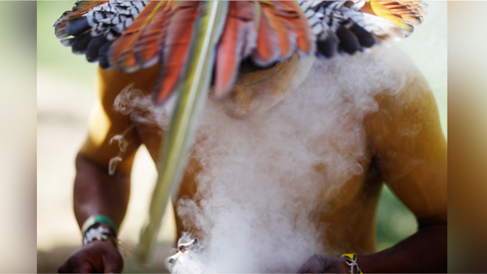 An indigenous man from the Pataxo tribe burns incense as he attends an assembly at Kari-Oca village in Rio de Janeiro.