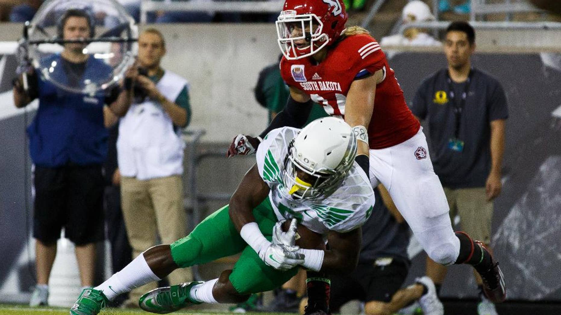 Oregon running back Byron Marshall makes a touchdown catch in the end zone during the second quarter of an NCAA college football game against South Dakota in Eugene, Ore., Saturday, Aug. 30, 2014. At right is South Dakota's Jacob Warner. (AP Photo/Ryan Kang)