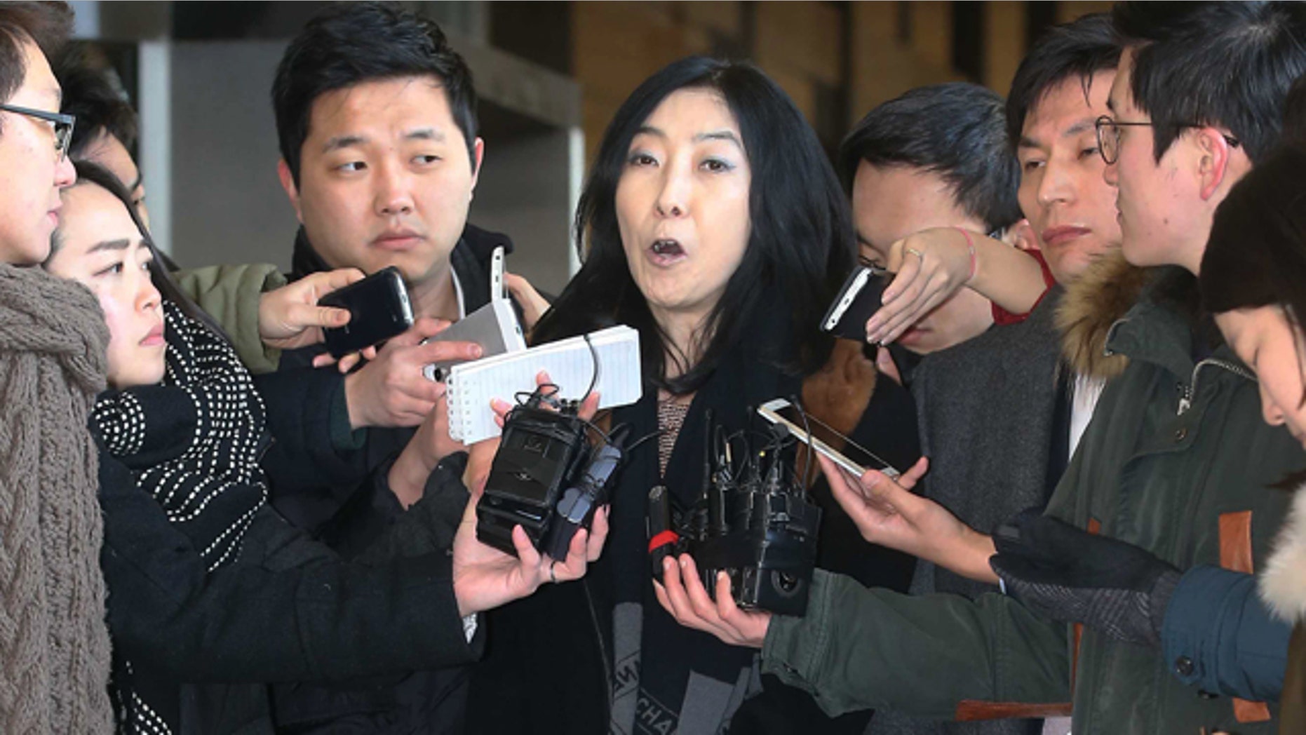 Jan. 7, 2015: California-resident Shin Eun-mi, center, talks to reporters at Seoul District Prosecutors' Office. South Korean officials say they were considering whether to deport the Korean-American woman accused of praising rival North Korea during a recent lecture. (AP Photo/Yonhap, Park Ji-ho)