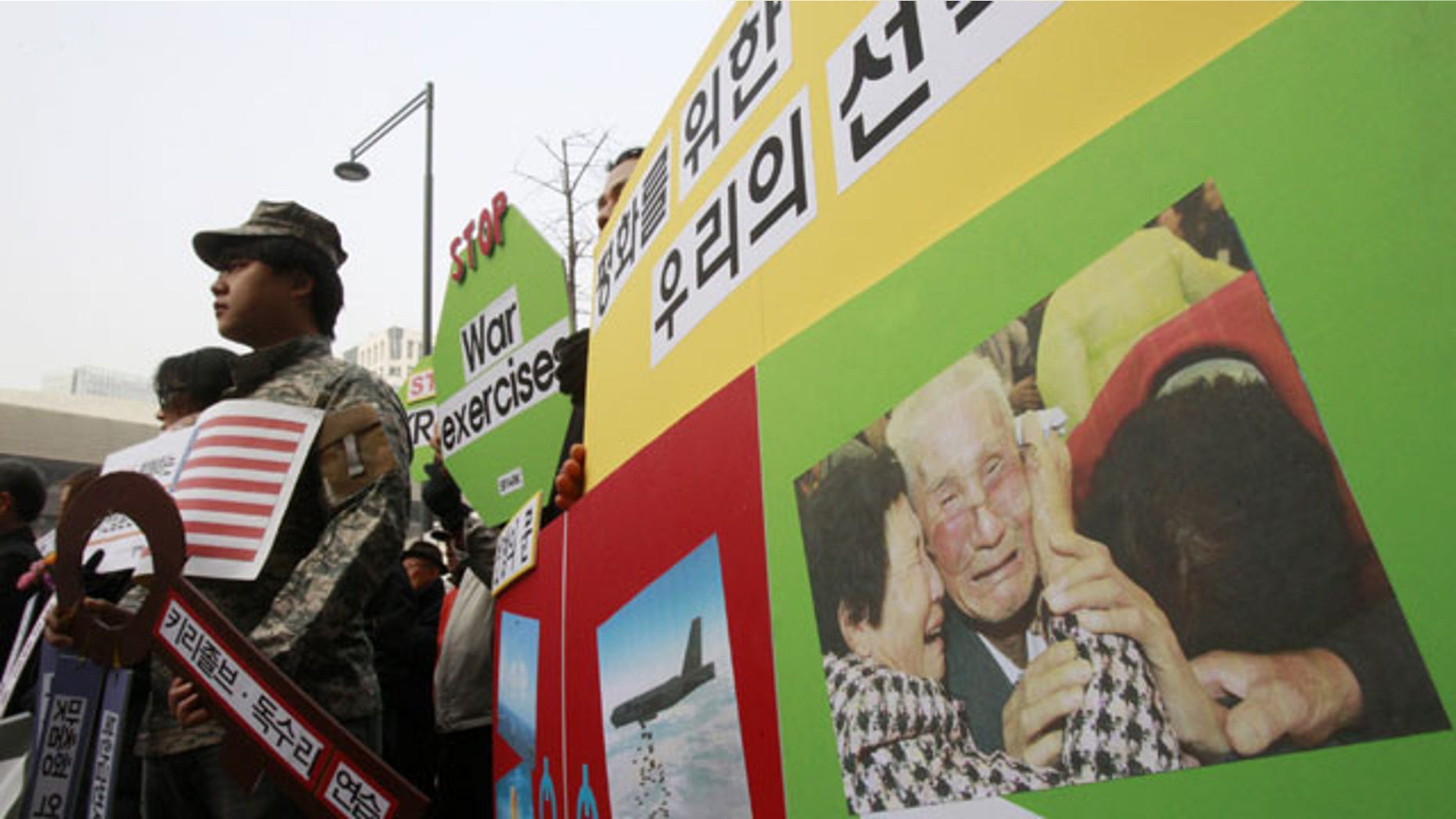 February 24, 2014: With a picture of South and North Korean family's reunion on display, protesters stage a rally denouncing the annual joint military exercises, dubbed Key Resolve and Foal Eagle, between South Korea and the United States, near the U.S. Embassy in Seoul, South Korea. (AP Photo/Ahn Young-joon)