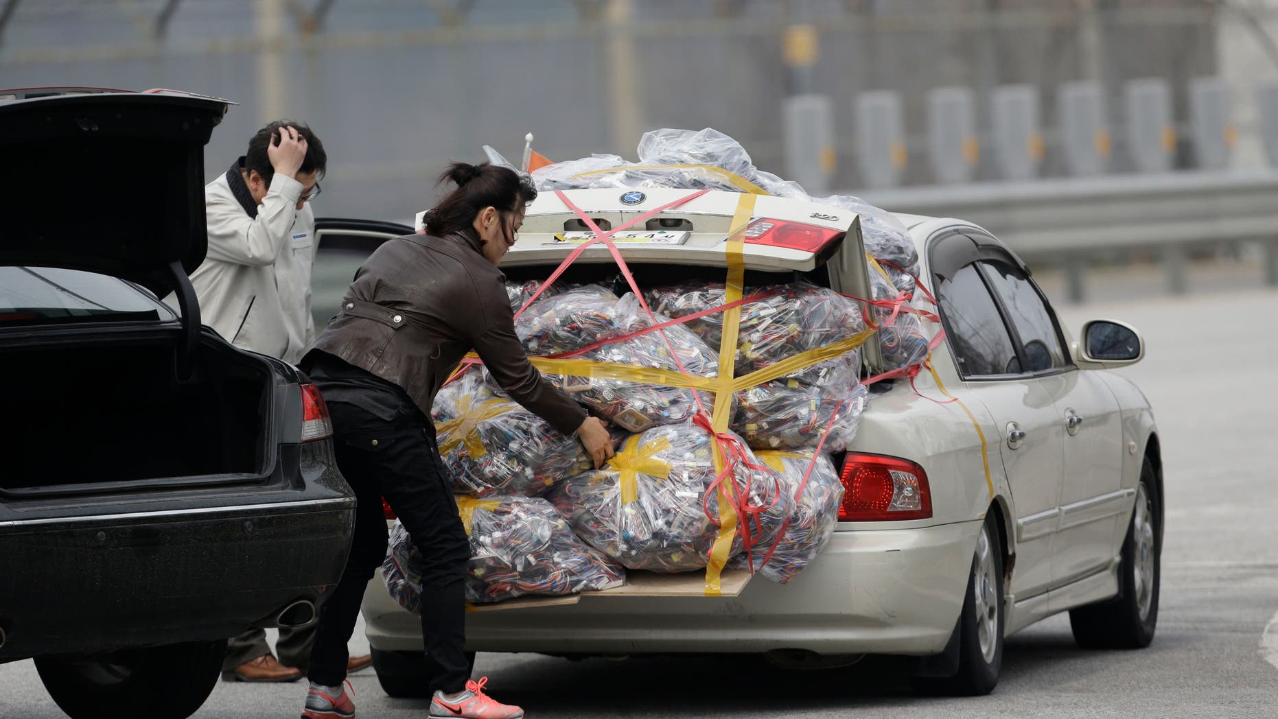 A South Korean worker, left, who arrives with electronic products from North Korea's Kaesong, is helped by a South Korean woman who greeted him, after returning from the North at the customs, immigration and quarantine office near the border village of Panmunjom, that has separated the two Koreas since the Korean War, in Paju, north of Seoul, South Korea, Monday, April 8, 2013.