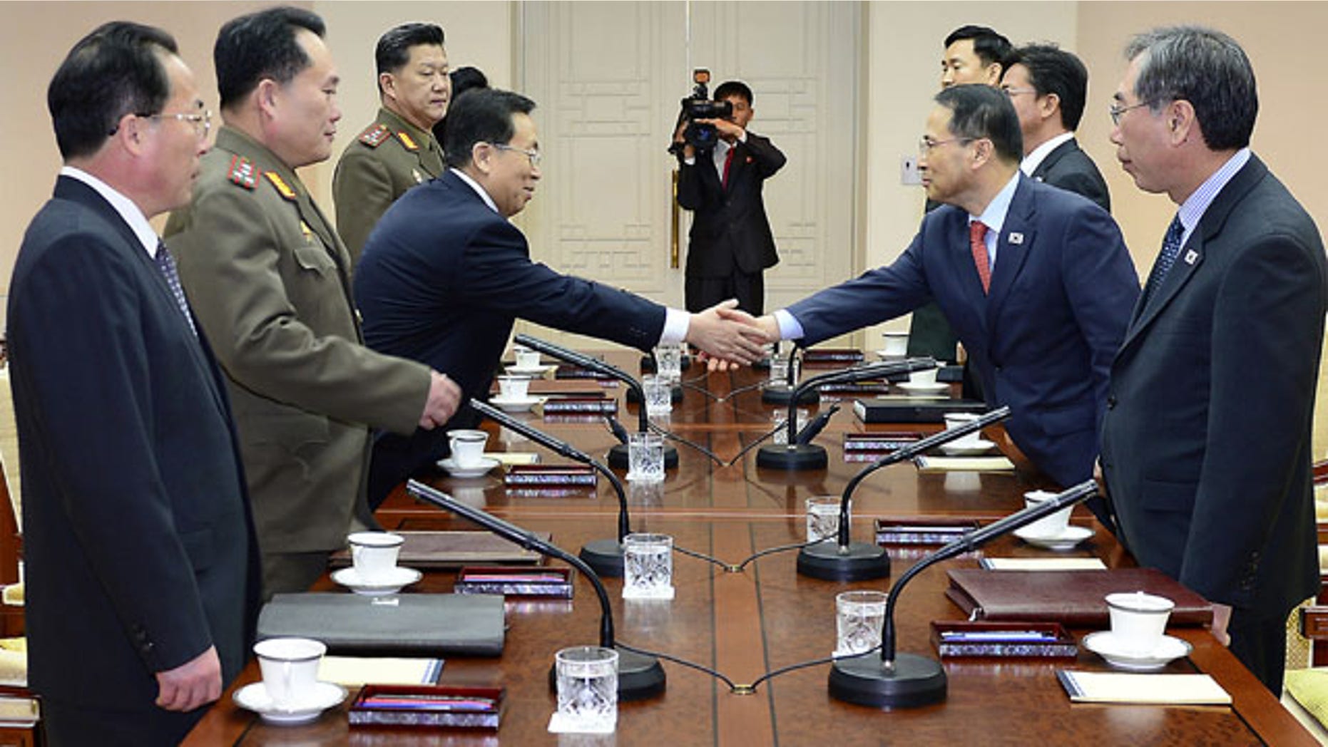 February 12, 2014: In this photo released by the South Korean Unification Ministry, South Korean chief delegate Kim Kyou-hyun, second from right, shakes hands with his North Korean counterpart Won Tong Yon, third from left, during their meeting at the border village of Panumjom, South Korea. (AP Photo/South Korean Unification Ministry)