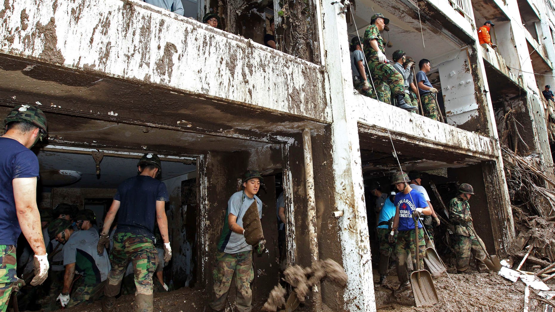 South Korean soldiers remove debris at a damaged apartment after a landslide caused by heavy rains in Seoul, South Korea, Thursday, July 28, 2011. Thousands of rescuers used heavy machinery and shovels Thursday to clear mud and search for survivors after huge landslides and flooding killed more than 40 people in South Korea.