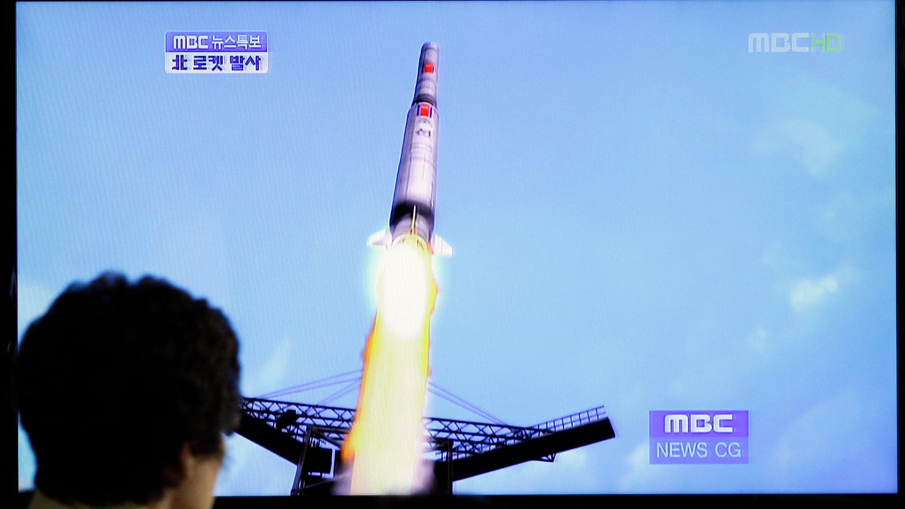 April 13, 2012: A South Korean woman watches a TV news report showing a computer generated image of North Korea's long-range rocket at Seoul train station in Seoul, South Korea.