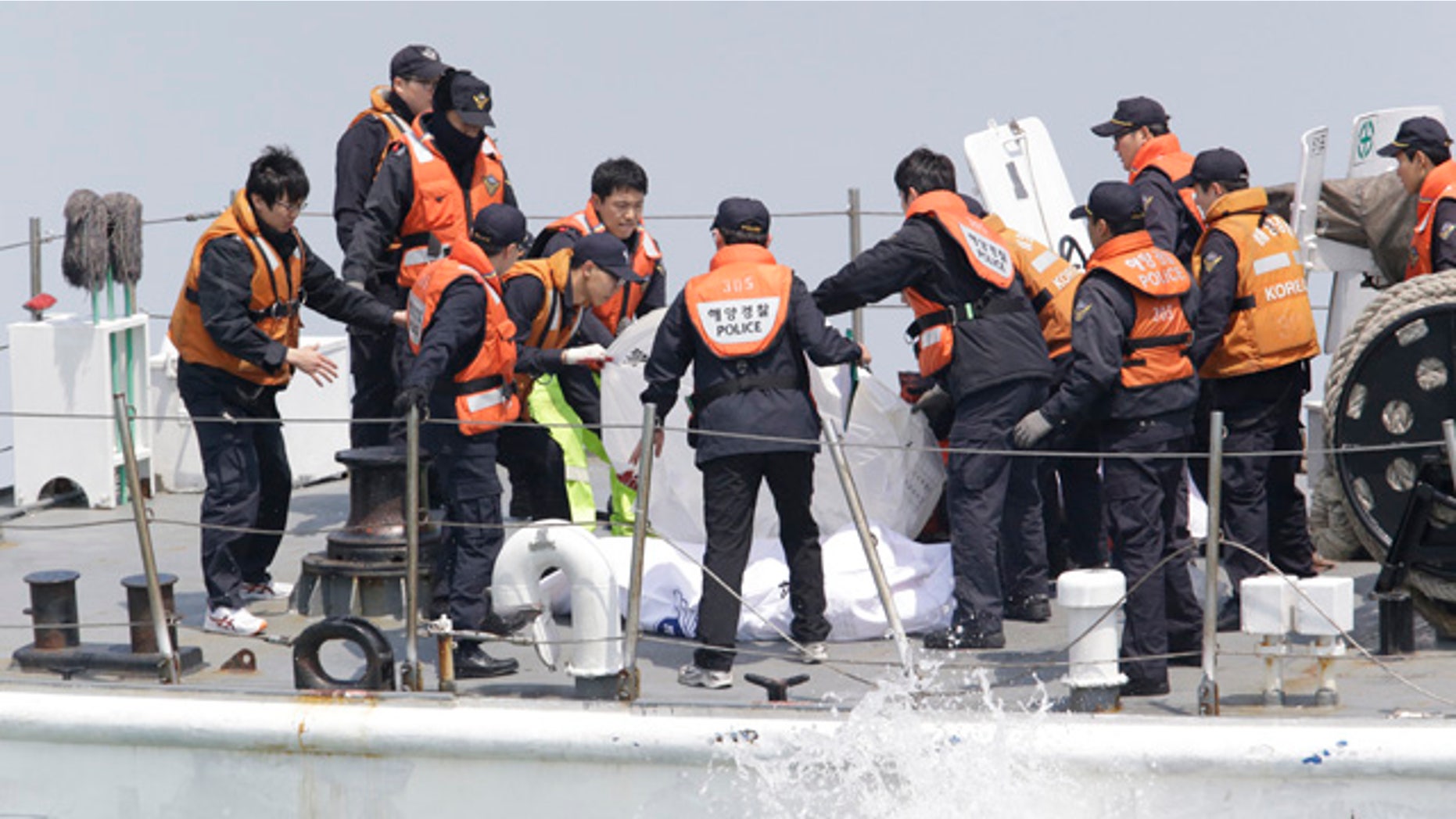April 20, 2014: South Korean Coast Guard police officers on a boat check the bodies of passengers believed to have been trapped in the sunken ferry Sewol in the water off the southern coast near Jindo, south of Seoul. (AP Photo/Lee Jin-man)