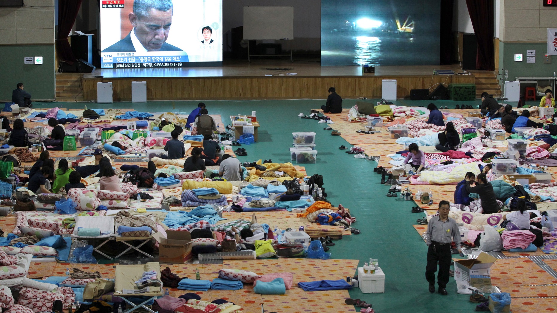 April 25, 2014 - A TV screen shows Pres. Obama paying silent tribute for the victims of South Korea's sunken ferry Sewol during a summit meeting with South Korean President Park Geun-hye as relatives of victims look on at a gymnasium in Jindo, South Korea. The South Korean government conceded that some bodies have been misidentified and announced changes to prevent such mistakes from happening again.