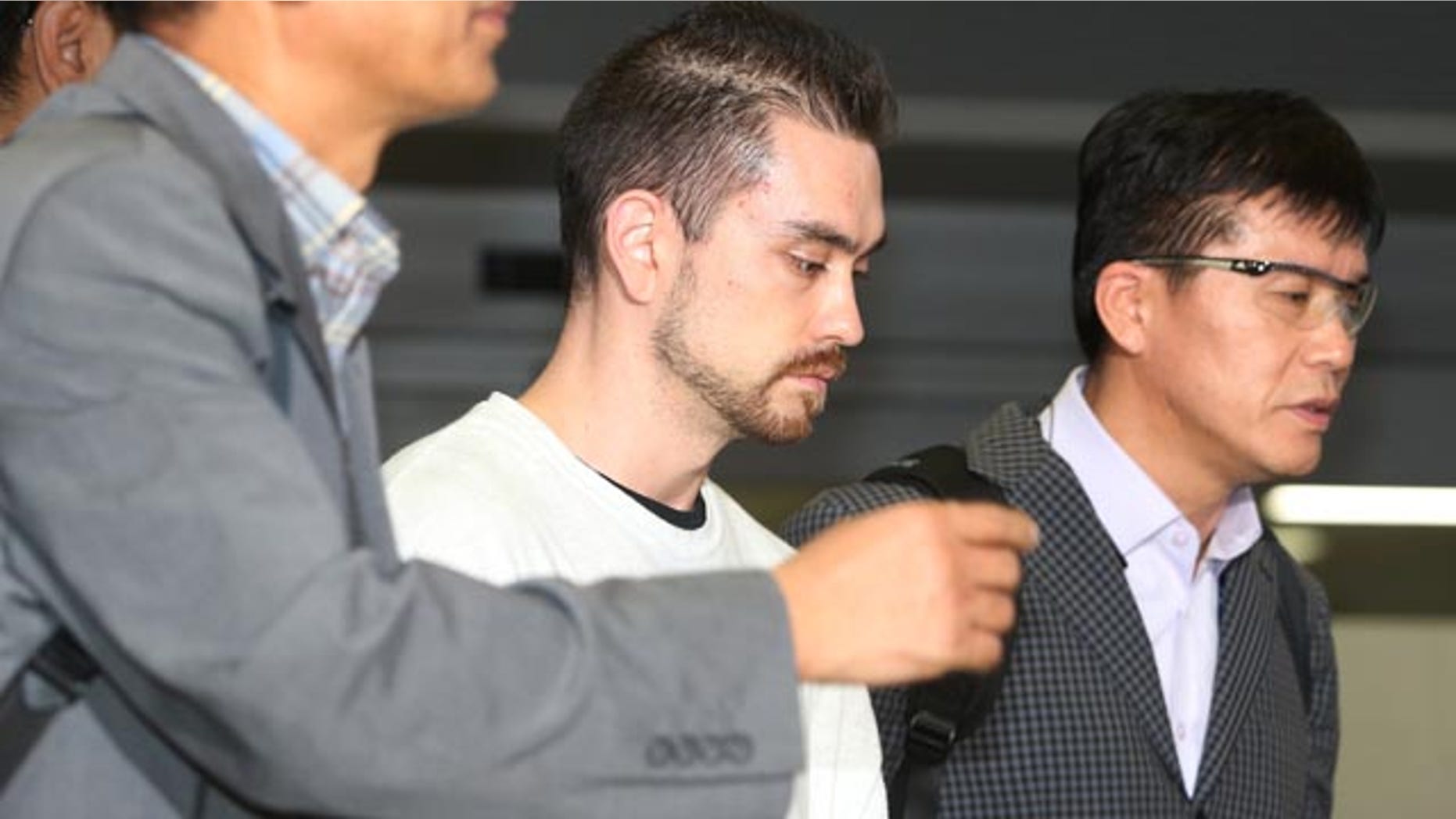Sept. 23, 2015: Arthur Patterson, center, an American charged with murdering a Seoul university student in 1997, is escorted by South Korean police officers upon his arrival at Incheon International airport. (Im Hun-jung/Yonhap via AP)