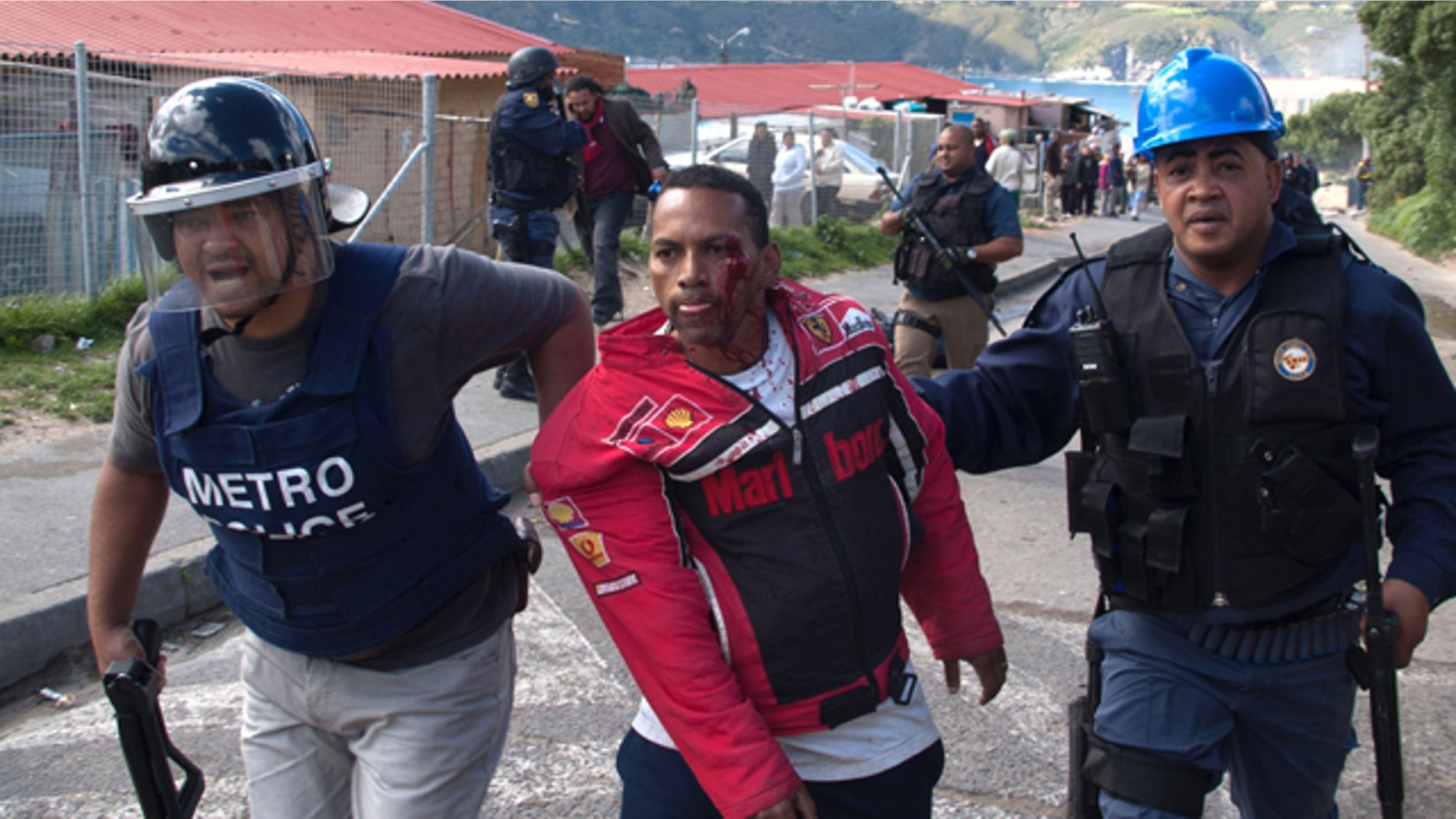 September 21: Police, escort an injured protestor after police took action against slum dwellers, during clashes in Cape Town, South Africa. (AP)