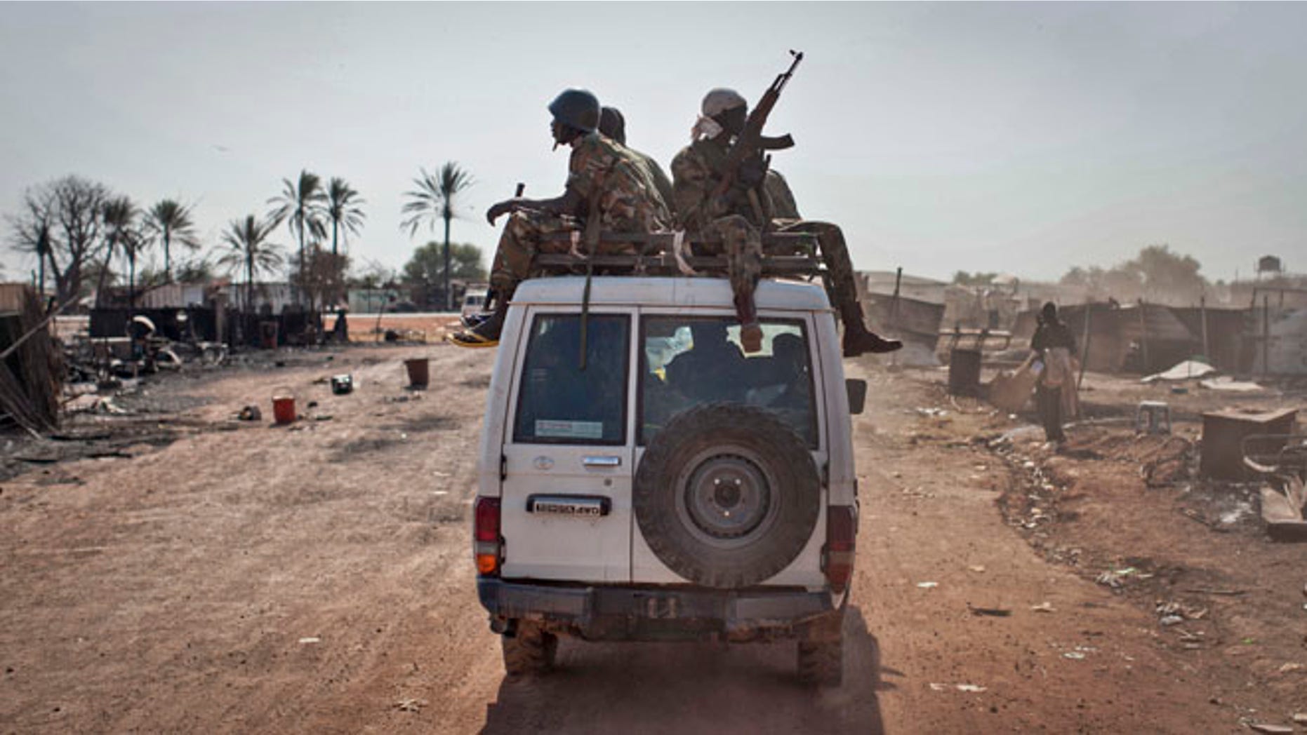 Jan. 12, 2014: In this file photo, South Sudanese government forces ride on a vehicle through the still-smoldering town, after government forces on Friday retook from rebel forces the provincial capital of Bentiu, in Unity State, South Sudan.