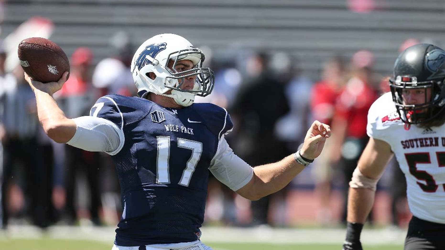 Nevada's Cody Fajardo (17) looks for an open receiver while being under pressure by Southern Utah's Josh Talbot (57) during the first half of an NCAA college football game on Saturday, Aug. 30, 2014, in Reno, Nev. (AP Photo/Cathleen Allison)