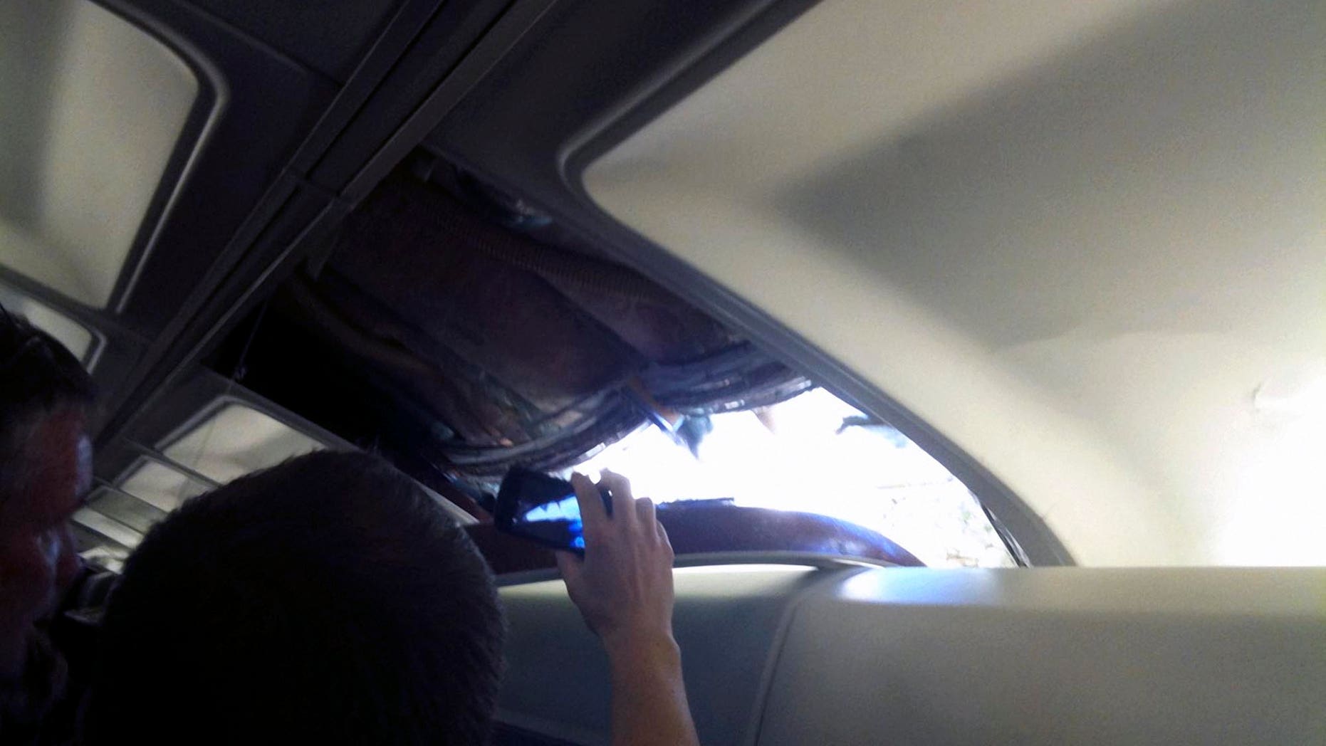 April 1: In this photo provided by passenger Brenda Reese, unidentified passengers take photos with cell phones of an apparent hole in the cabin on a Southwest Airlines aircraft in Yuma, Ariz. Authorities say the flight from Phoenix to Sacramento, Calif., was diverted to Yuma due to rapid decompression in the plane. FAA spokesman Ian Gregor says the cause of the decompression isn't immediately known. But passengers aboard the plane say there was a hole in the cabin and that forced an emergency landing. (AP)