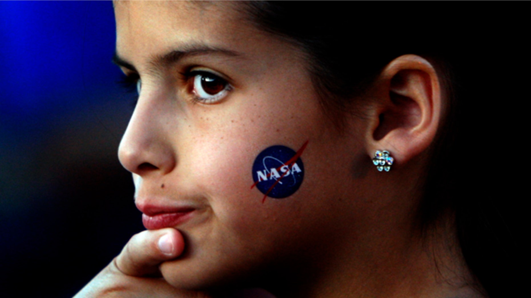 May 22, 2011: Fourth grader Alexandra Doe has a NASA symbol on her cheek as she waits to be called inside as Mesa Verde Elementary School students talk with Shuttle Endeavour astronauts.