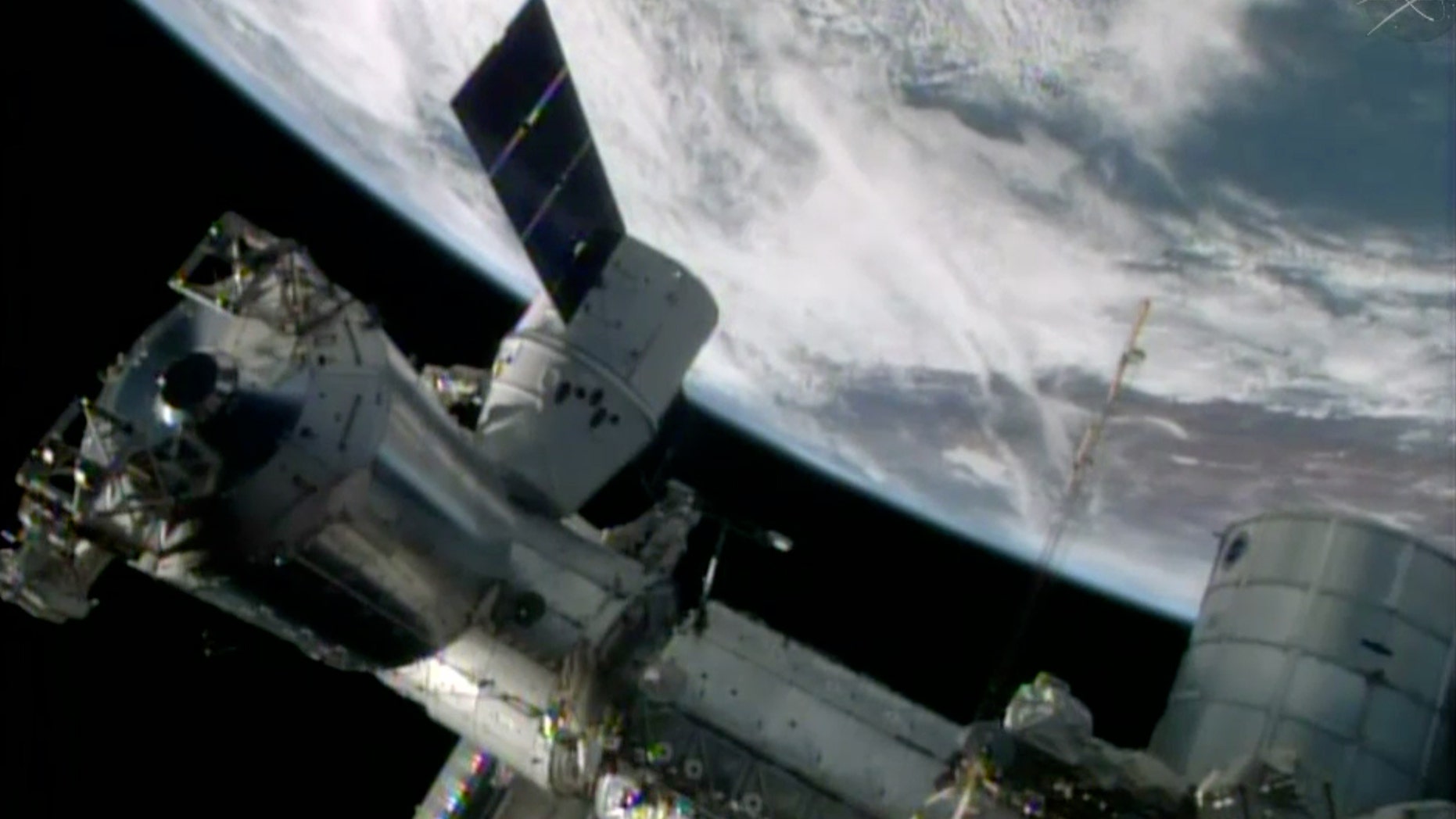 FILE- In this April 20, 2014, image made from a frame grabbed from NASA-TV, the SpaceX Dragon resupply capsule begins the process of being berthed on to the ISS.