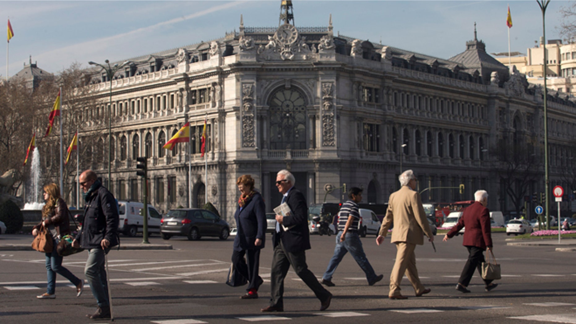 People cross the street in front of Spain's Central Bank in Madrid, Spain, Thursday, March 12, 2015. The entire board of Spainâs Banco de Madrid bank catering to wealthy clients has resigned after its Andorran owner was accused by the U.S. of money laundering for clients from China, Russia and Venezuela, Banco de Madrid said Thursday. (AP Photo/Paul White)