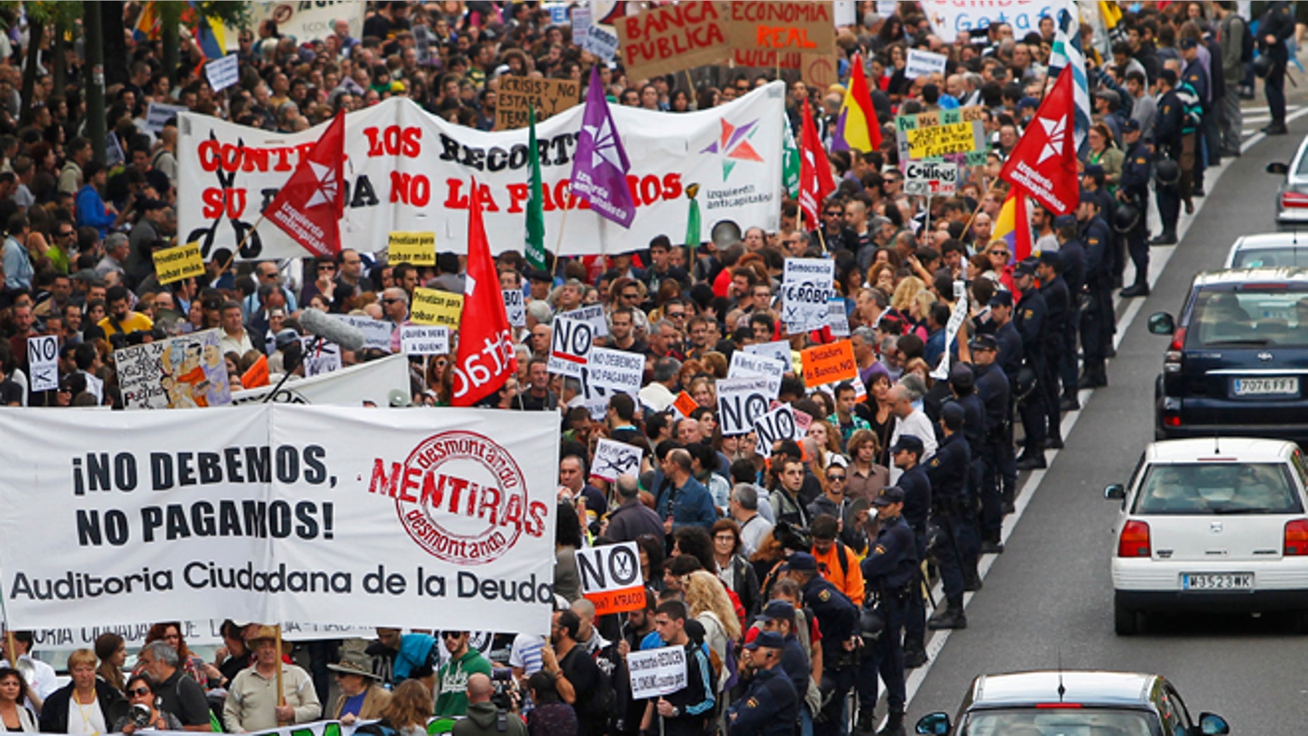Protestor march as they hold banners reading âWe don't owe, we won't payâ against austerity measures announced by the Spanish government in Madrid, Spain, Saturday, Oct. 13, 2012. Several thousand people noisily banging pots and pans marched down Madrid's main north-to-south boulevard protesting the government's austerity measures. With unemployment nearing 25 percent, Spain has introduced biting austerity measure as well as financial and labor reforms in a desperate bid to lower its deficit and assuage investors' misgivings. (AP Photo/Andres Kudacki)
