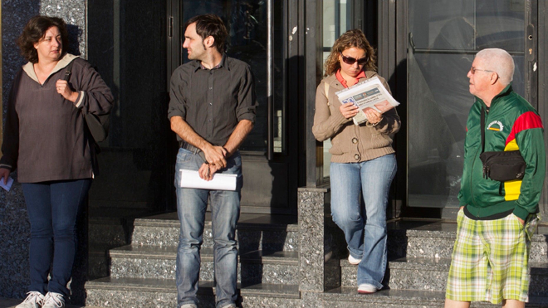 A woman reads a newspaper with the headline ' Public transport tickets have gone up 31 per cent after the recent V.A.T. tax hike' in a queue outside an unemployment registry office in Madrid, Tuesday Sept. 4, 2012. Spain says the number of people registered unemployed and claiming benefits rose in August by 38,179 people compared to the previous month, the first increase in five months in a deepening recession. At the end of the second quarter Spain reached the European Unionâs highest unemployment rate at 24.6 percent, a new overall rate wonât be released until October. (AP Photo/Paul White)