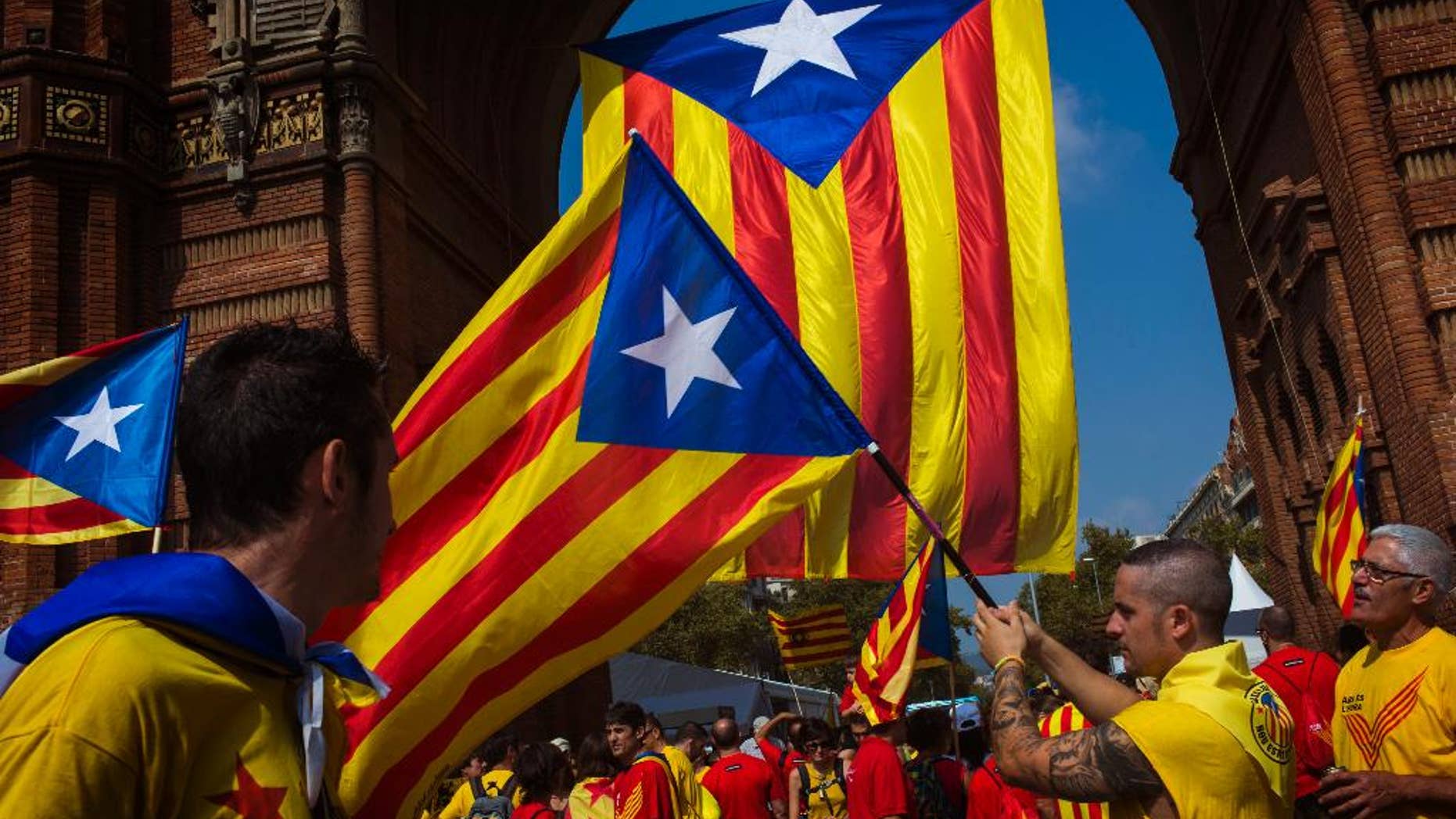 People wave “estelada” flags, that symbolize Catalonia's independence, in Barcelona, Spain, Thursday, Sept 11, 2014. A week before Scotland votes on whether to break away from the United Kingdom, separatists in northeastern Spain were trying to convince hundreds of thousands to protest across Catalonia to demand a secession sentiment vote that the central government in Madrid insists would be illegal. (AP Photo/Emilio Morenatti)