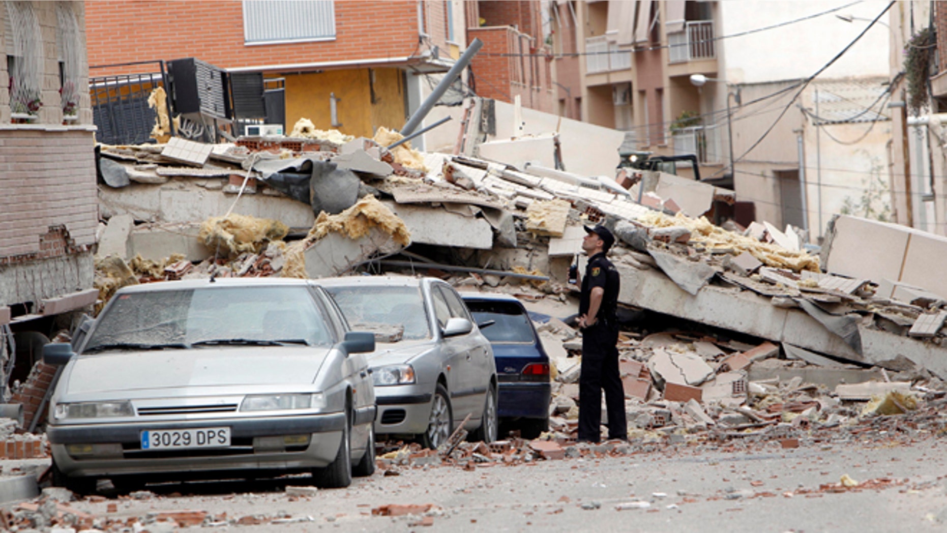 May 12, 2011: A police officer inspects damage caused by an earthquake the previous day in Lorca, Spain. Farmers drilling ever deeper wells over decades to water their crops likely contributed to the deadly earthquake in southern Spain last year, a new study suggests.