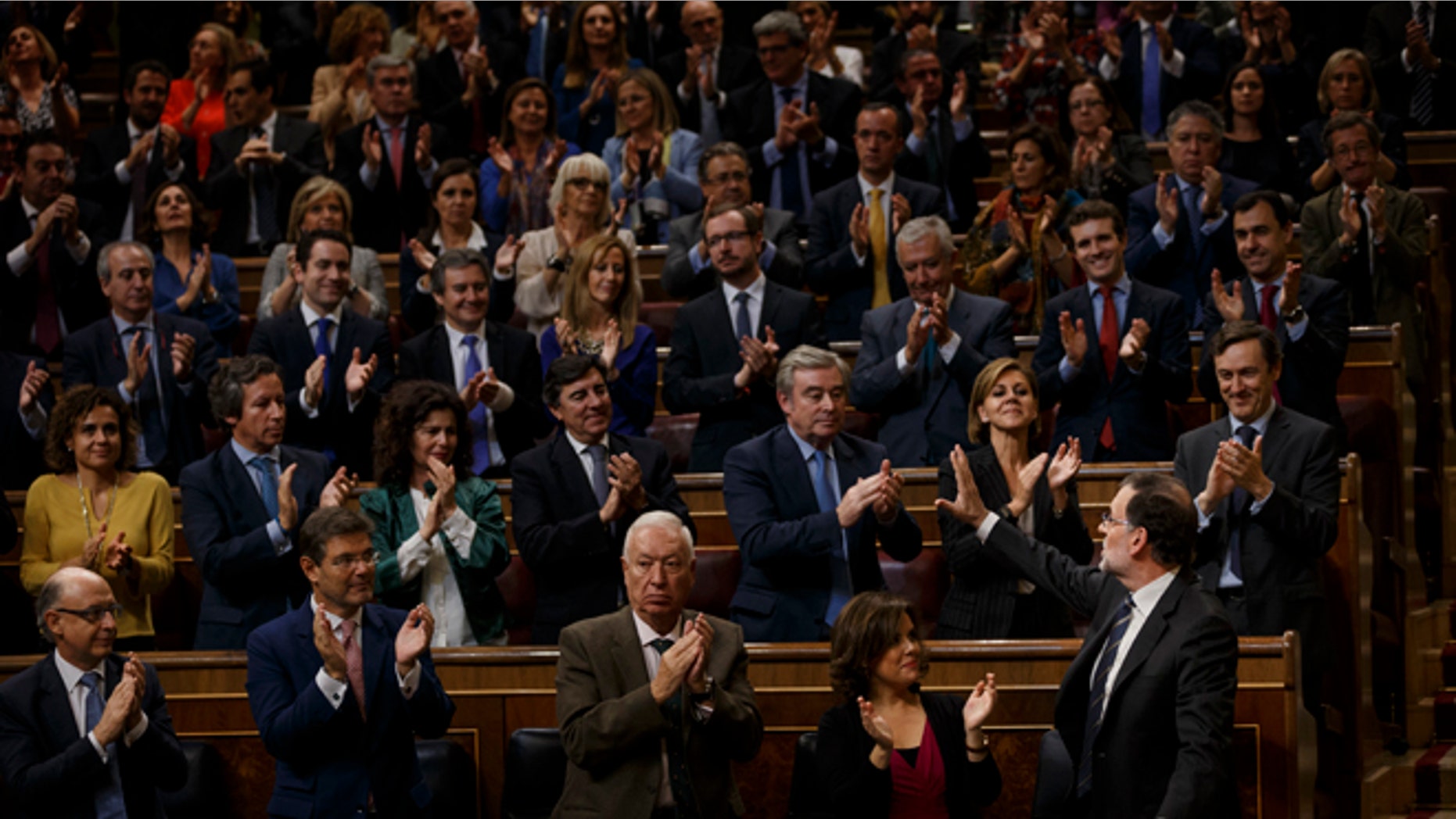 Spain acting conservative Prime Minister and Popular Party leader Mariano Rajoy, right, is greeted by his party members after speaking at the investiture debate, a day before a first confidence vote in Madrid, Spain, Wednesday, Oct. 26, 2016. The Spanish Parliament has started an investiture debate that is widely expected to end in the conservative Popular Party taking power later this week, ending 10 months of political deadlock during which a caretaker government has run the country. (AP Photo/Daniel Ochoa de Olza)