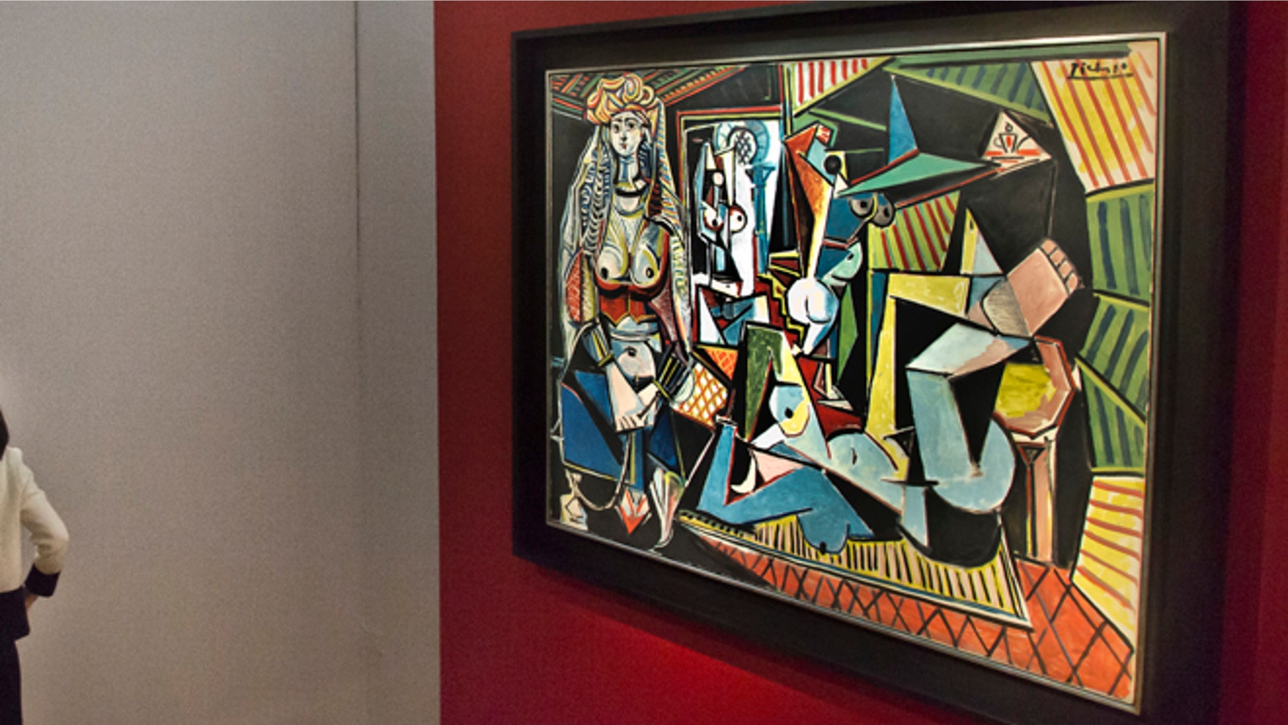 Visitors are introduced to the bronze sculpture "L'homme au doigt" by Alberto Giacometti, left, after viewing the Pablo Picasso oil painting "Les femmes d'Alger," right, during Christie's Spring 2015 Evening Sale press preview, Friday, May 1, 2015, in New York. New York City's spring art auctions get underway Tuesday with work from prominent artists fueling a robust market for impressionist, modern and contemporary art. (AP Photo/Bebeto Matthews)
