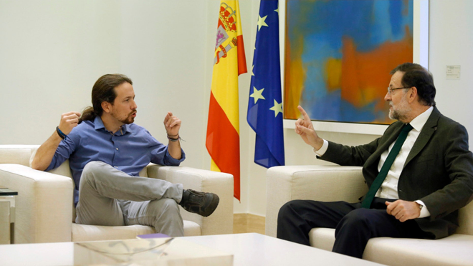 FILE - In this Oct. 30, 2015 file photo, Spain's Prime Minister Mariano Rajoy, right, talks to Podemos party leader Pablo Iglesias during their meeting at the Moncloa palace, the Spanish premier's official residence, in Madrid. Rajoy is meeting with the leaders of two upstart parties on Monday Dec. 28, 2015 following an election that gave Rajoys party the most votes but left it far short of a parliamentary majority. Rajoy is seeking support for his center-right Popular Party to govern as a minority party or in a coalition but his options are limited. (AP Photo/Francisco Seco, File)