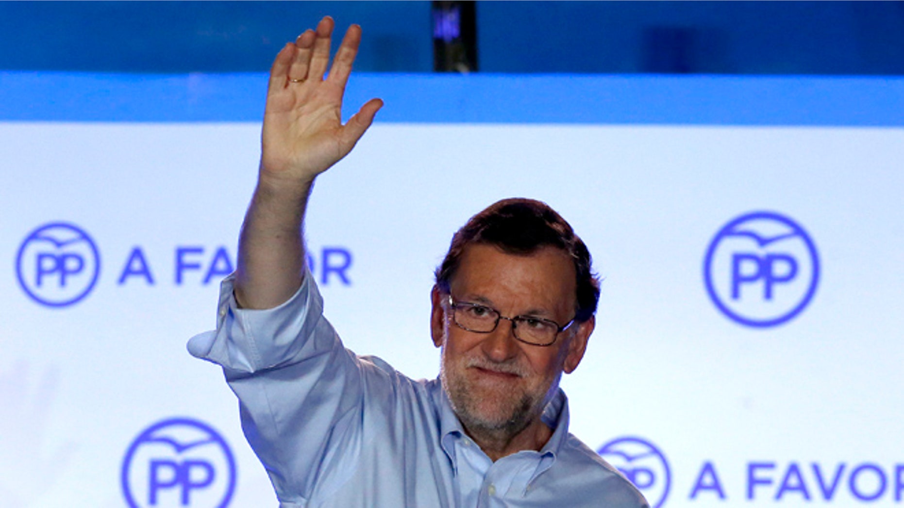 Spain's acting Primer Minister and candidate of Popular Party Mariano Rajoy, waves to his supporters as he celebrates the results of the party during the national elections in Madrid, Spain, Sunday, June 26, 2016. Spain's repeat election on Sunday failed to clarify the political future of the European Union's fifth-largest economy, with the main parties placing roughly the same as in last December's ballot, which brought six months of stalemate. (AP Photo/Daniel Ochoa de Olza)
