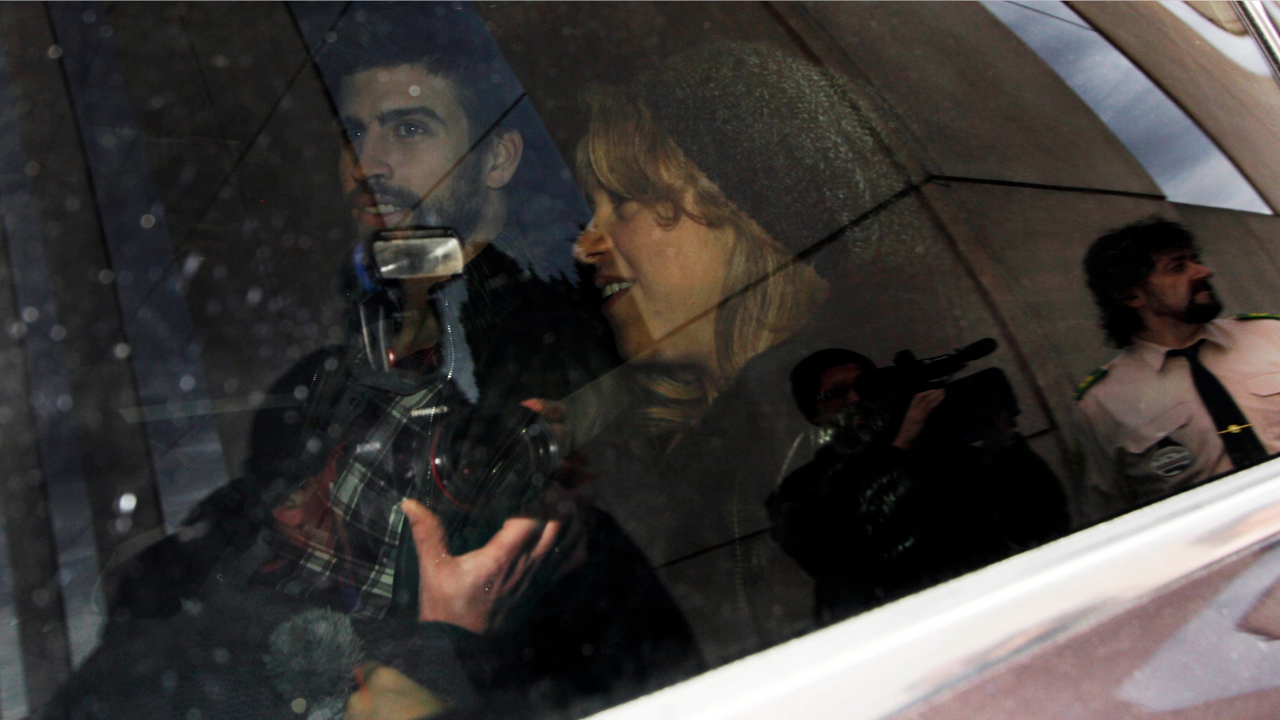 Jan. 27, 2013: FC Barcelona's Gerard Piqué, left, and Shakira, right, and their son, unseen, leave a hospital surrounded by media, in Barcelona, Spain.