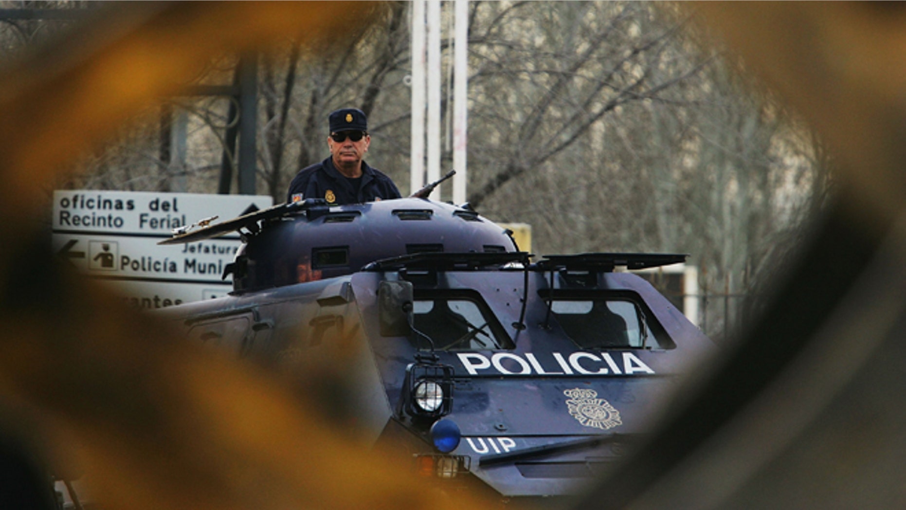 MADRID, SPAIN - FEBRUARY 15: A digger passes an armoured police vehicle at the Madrid National Court in the Casa de Campo, on the first day of the Madrid train bombings trial, on February 15, 2007 in Madrid, Spain. The March 2004 attack on commuter trains killed 119 and wounded 1,700 people. (Photo by Denis Doyle/Getty Images)
