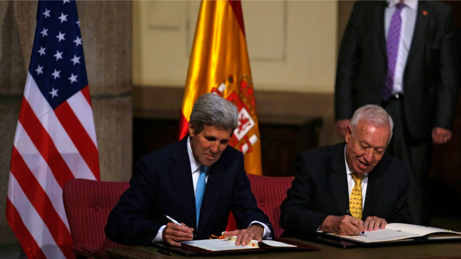 U.S. Secretary of State John Kerry, left, and Spain's Foreign Minister Jose Manuel Garcia Margallo sign agreements at the Santa Cruz palace, Spain's Foreign Affairs Ministry, in Madrid, Spain, Monday, Oct. 19, 2015. Spain and the United States signed an agreement Monday to further discuss the cleanup and removal of land contaminated with radioactivity after a mid-air collision in 1966 dumped four U.S. hydrogen bombs near the southern Spanish village of Palomares. (AP Photo/Francisco Seco)