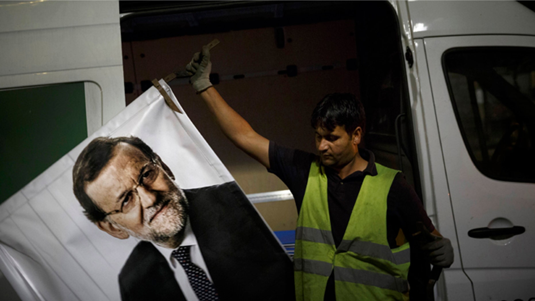 A worker removes a campaign poster for the national elections depicting Spain's Prime Minister and Popular Party candidate Mariano Rajoy, in Madrid, Spain, Monday, Dec. 21, 2015. A strong showing Sunday by a pair of upstart parties in Spain's general election upended the country's traditional two-party system, with the ruling Popular Party winning the most votes but falling far short of a parliamentary majority and at risk of being booted from power. (AP Photo/Daniel Ochoa de Olza)